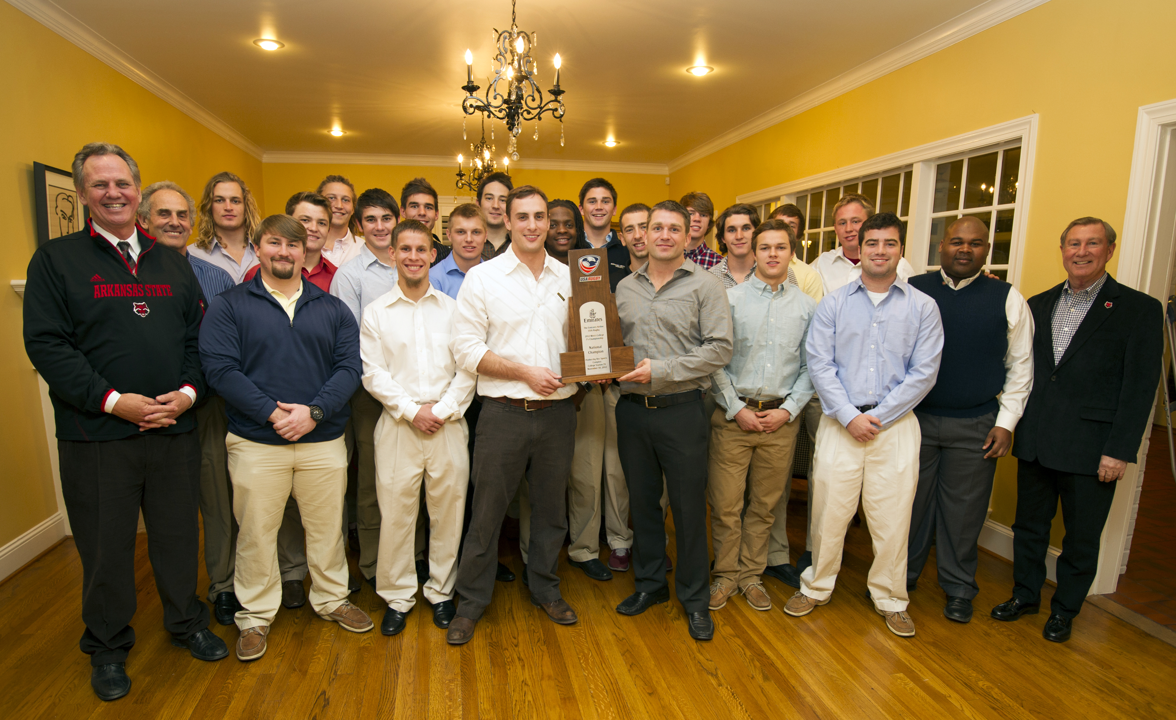 Pictured:  Chancellor Tim Hudson (far left) and Board of Trustees member Mike Gibson (far right) flank the 2012 National Champion College 7s rugby team. Former head coach Matt Huckaby (left in center) and new head coach Alex Houser hold the championship trophy.