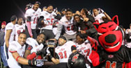 Players gather around the GoDaddy Bowl trophy with Howl