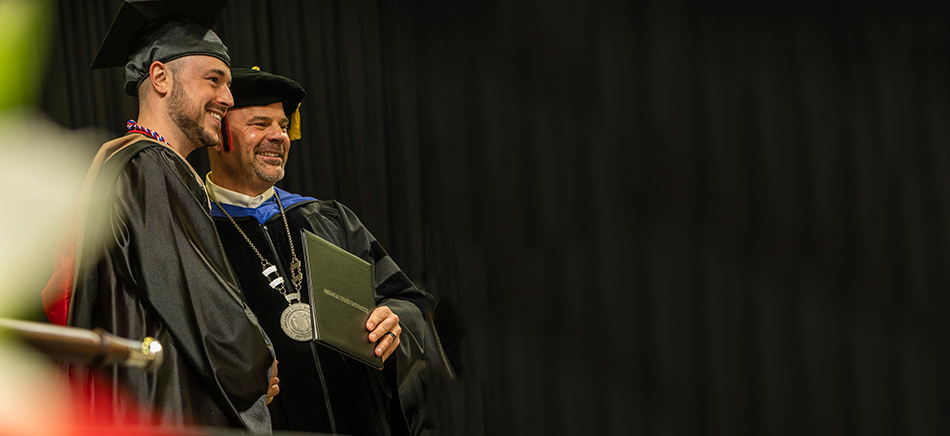 Todd Shields presents a degree to a graduate