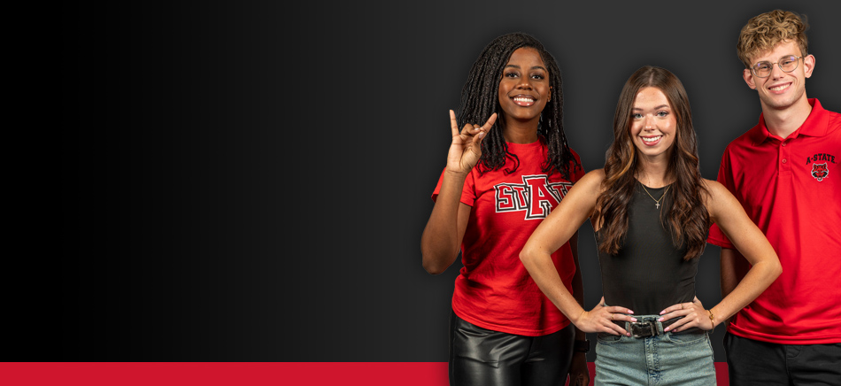 Three students from A-State smiling with their Wolves Up!