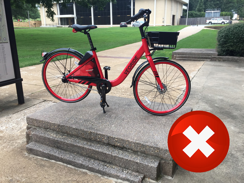 A bike locked to a building pipe