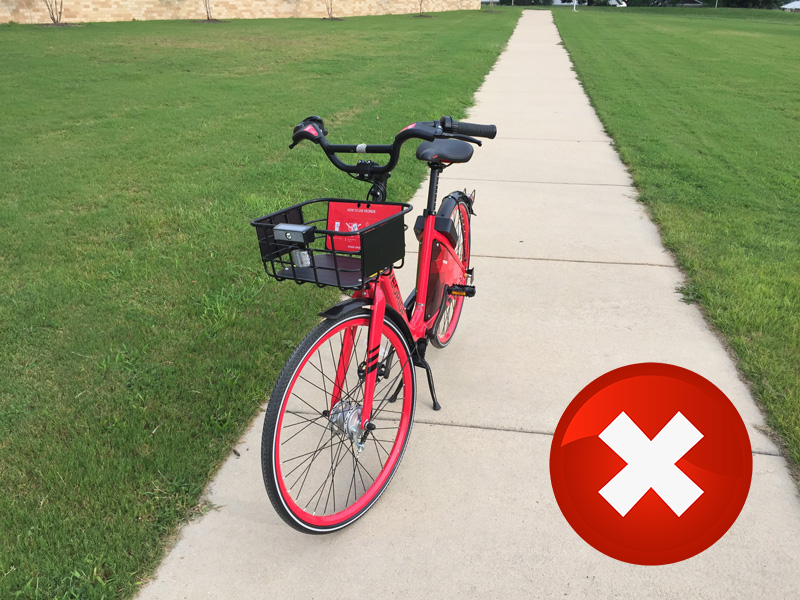 A bike locked to a building pipe