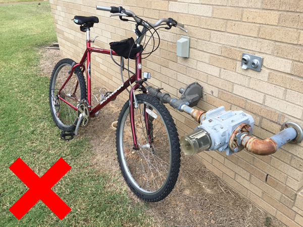 A bike locked to a building pipe