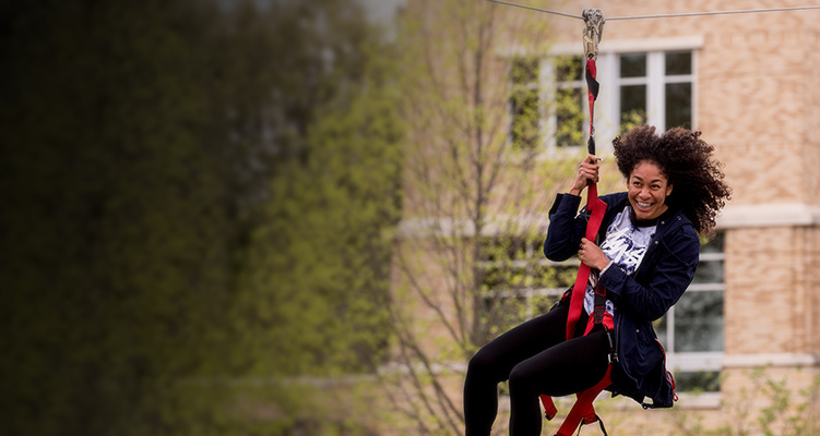 A student on a zipline on campus