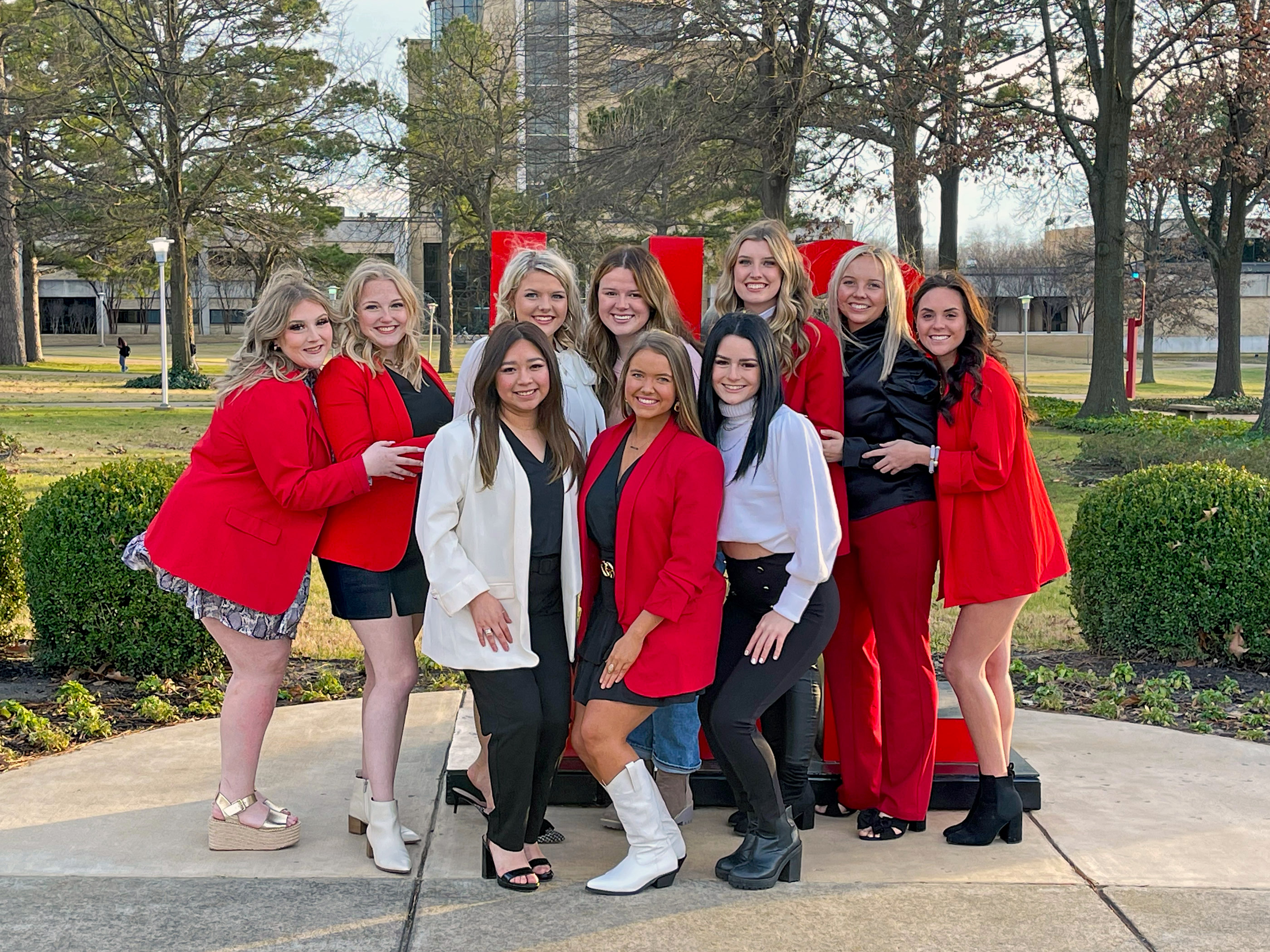 NPC student leaders pose in front of HOWL sculpture on the campus of A-State