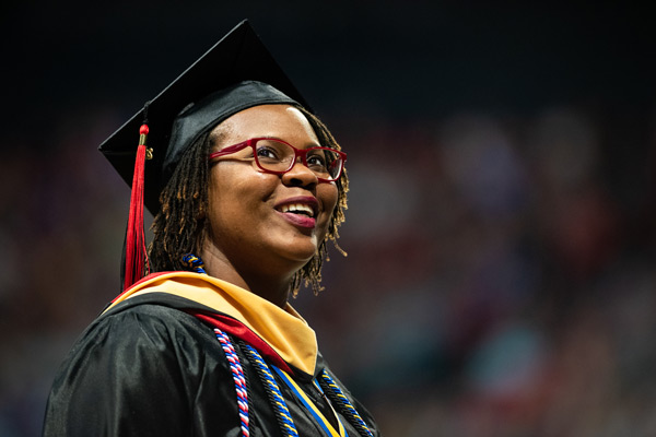 A graduate looks up at her family at commencement.