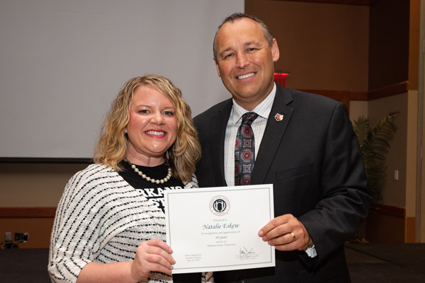 An employee receives an award from the chancellor.