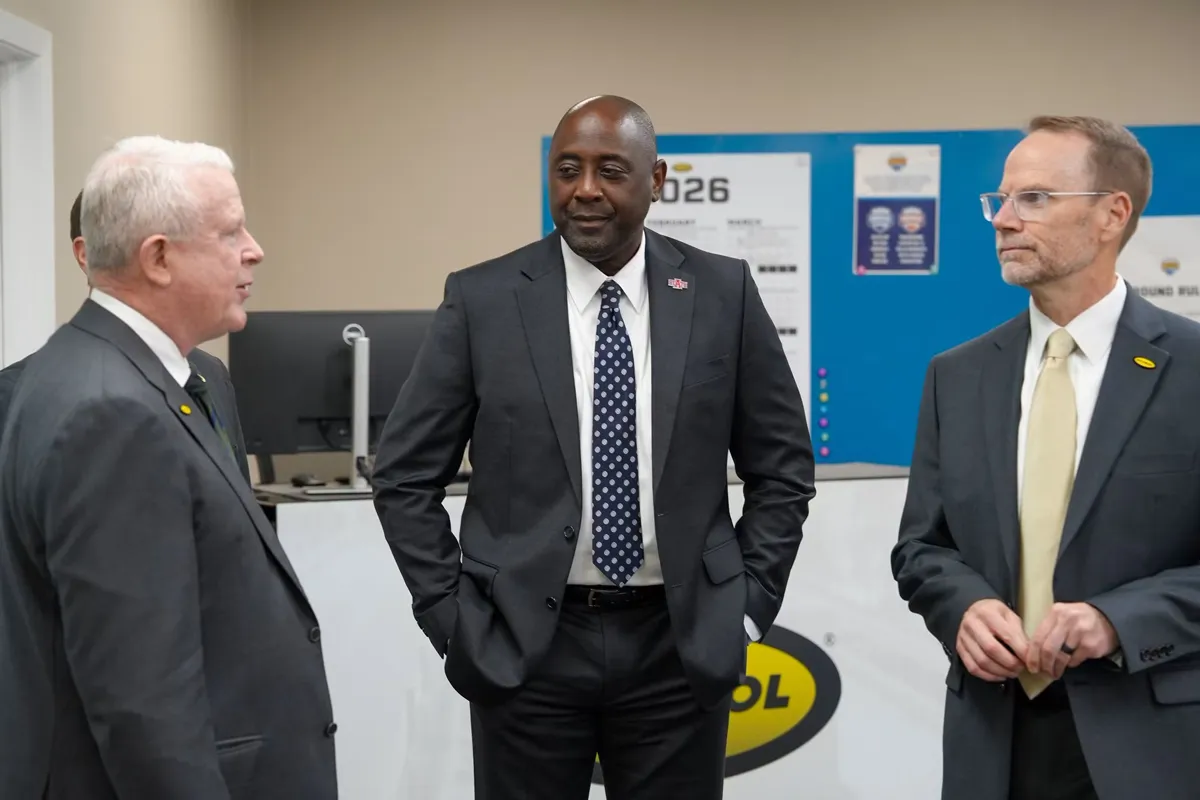 Dr. White visits with David Peacock and Phillip Poston from Hytrol at a check presentation ceremony