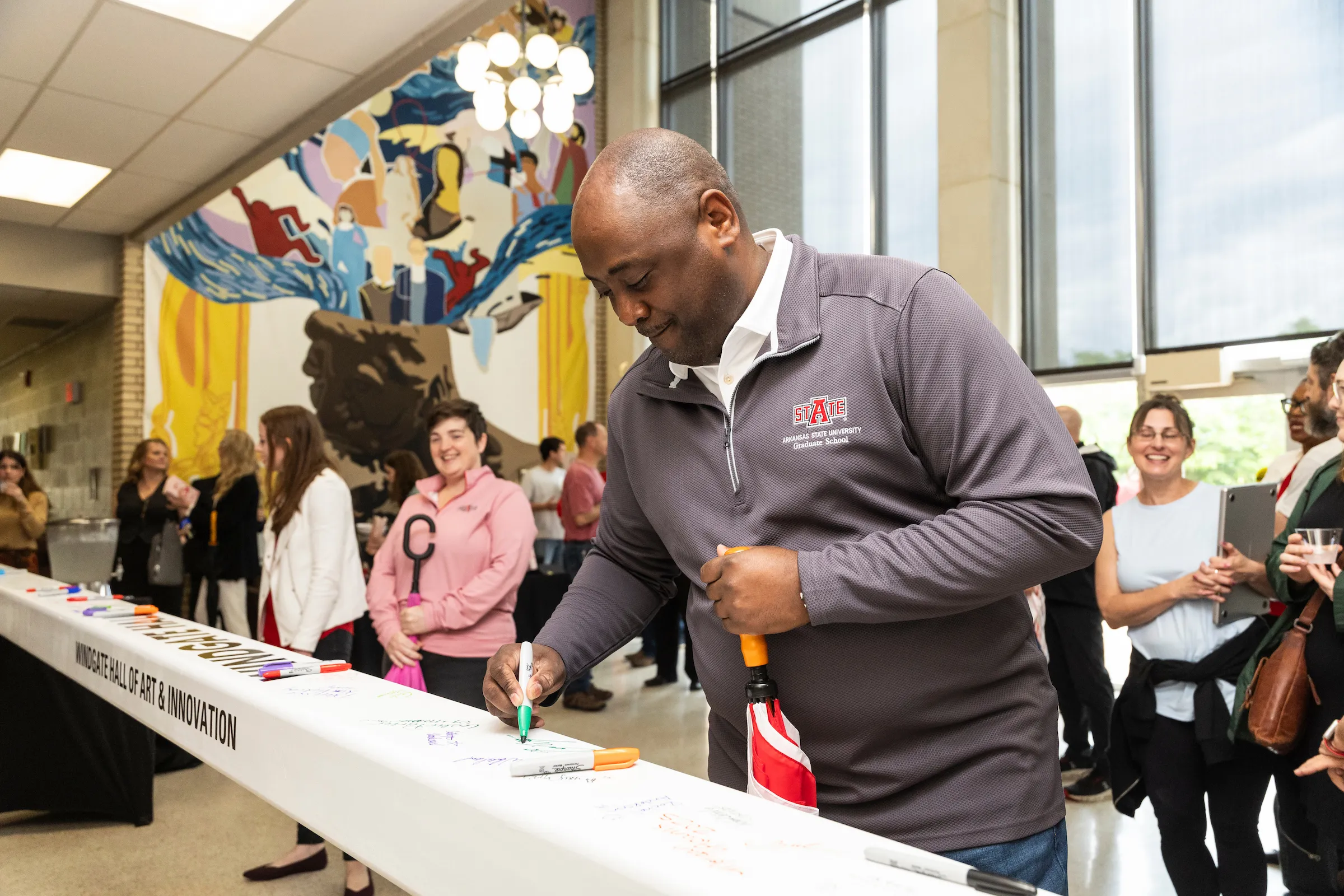 Dr. Calvin White signs the final beam of the Windgate Hall of Art and Innovation