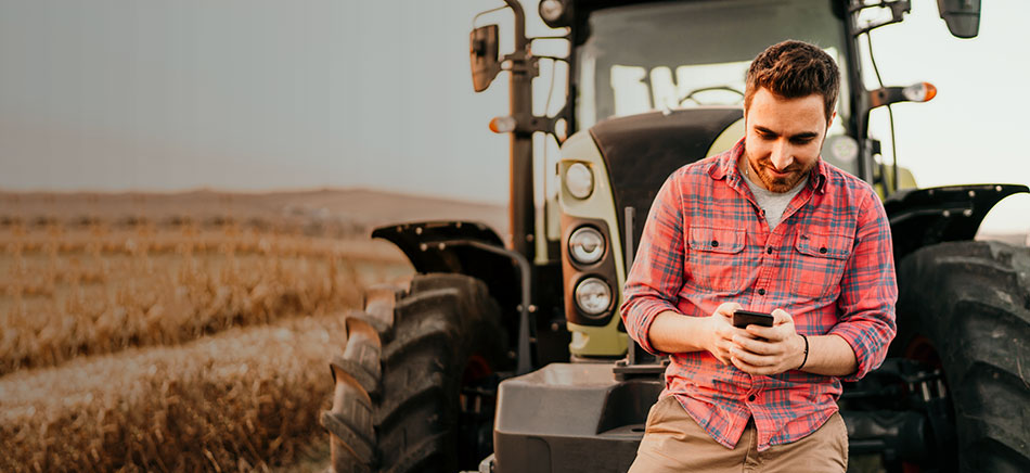 A student checking his phone on the farm