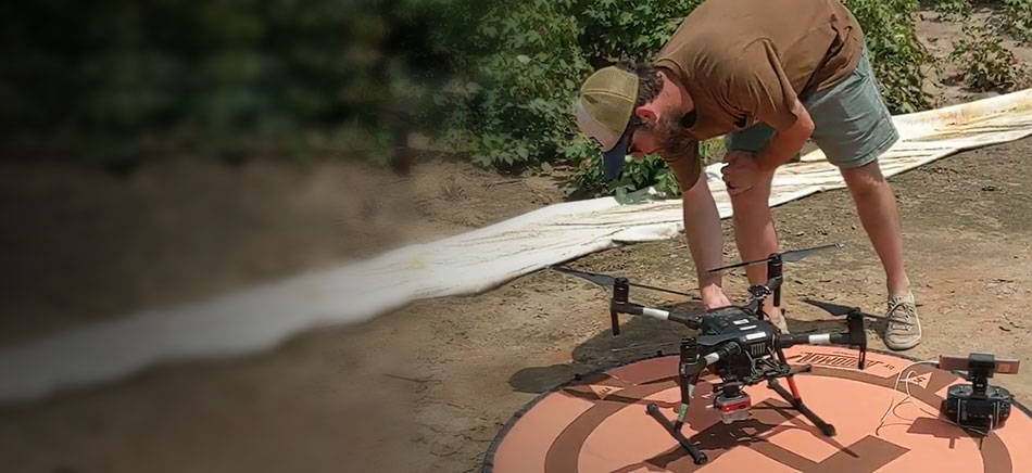 A student working on a drone in a field