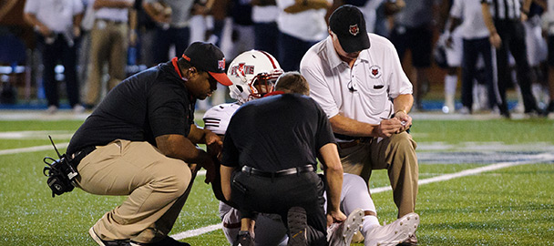 Athletic trainers attending to an injured football player