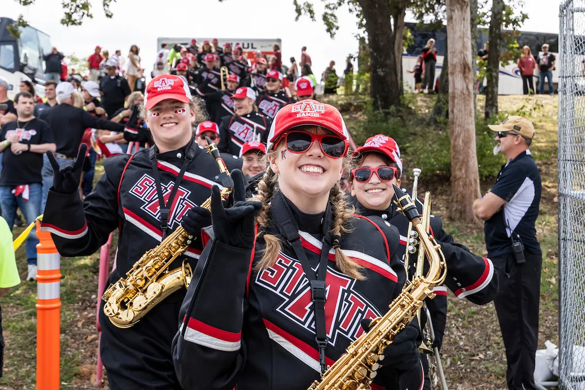 Band members smile at the camera after a pep rally