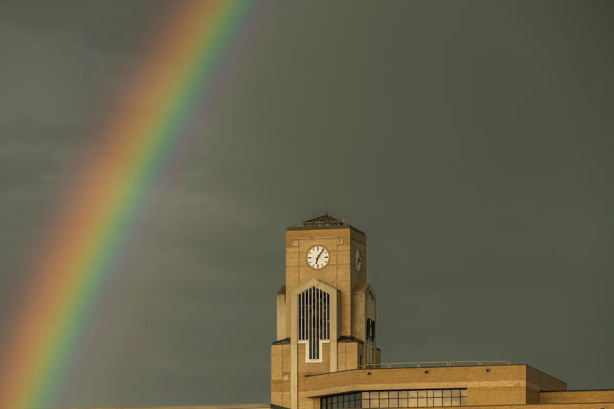 A rainbow appears near the Dean B Ellis Library Clocktower