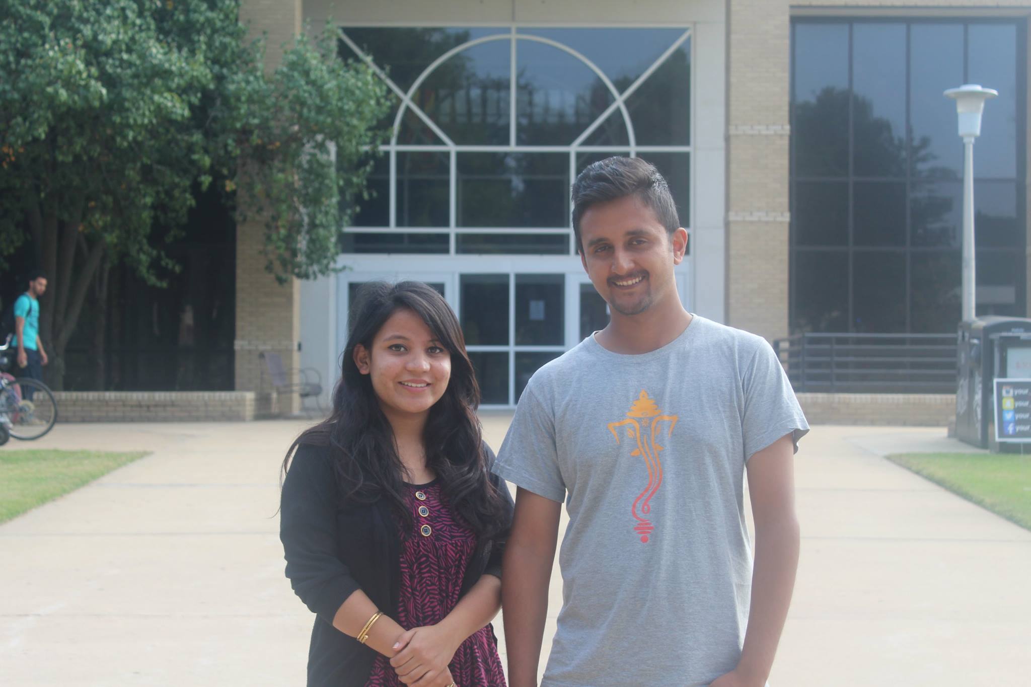 a male and female student standing side by side; both are international