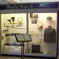 exhibit case with uniforms and guns in the Military Gallery