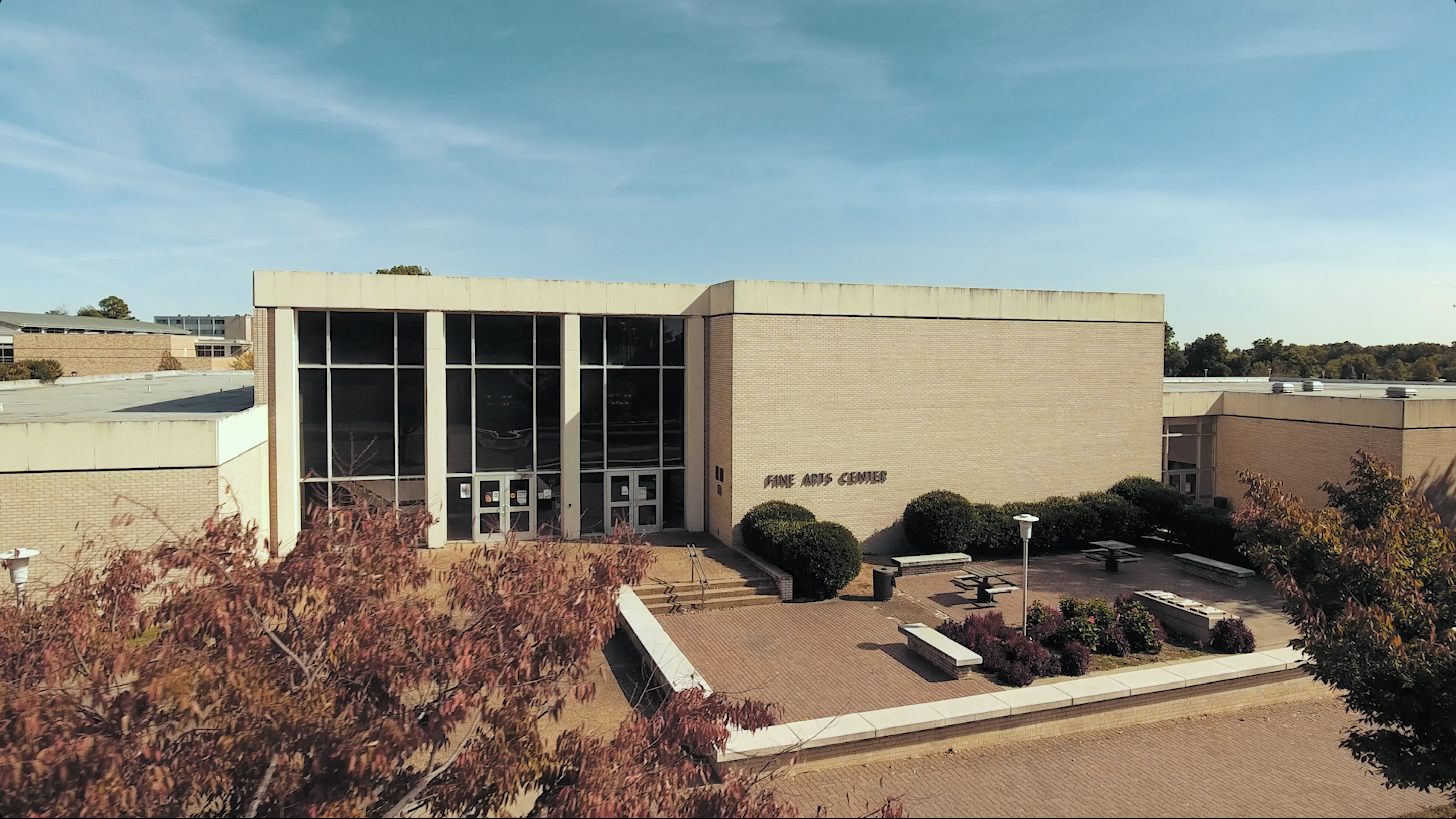 Aerial view of the Fine Arts Center building.  The front has floor to ceiling windows.  The building is cream brick with the words Fine Arts Center on the right side of the building.
