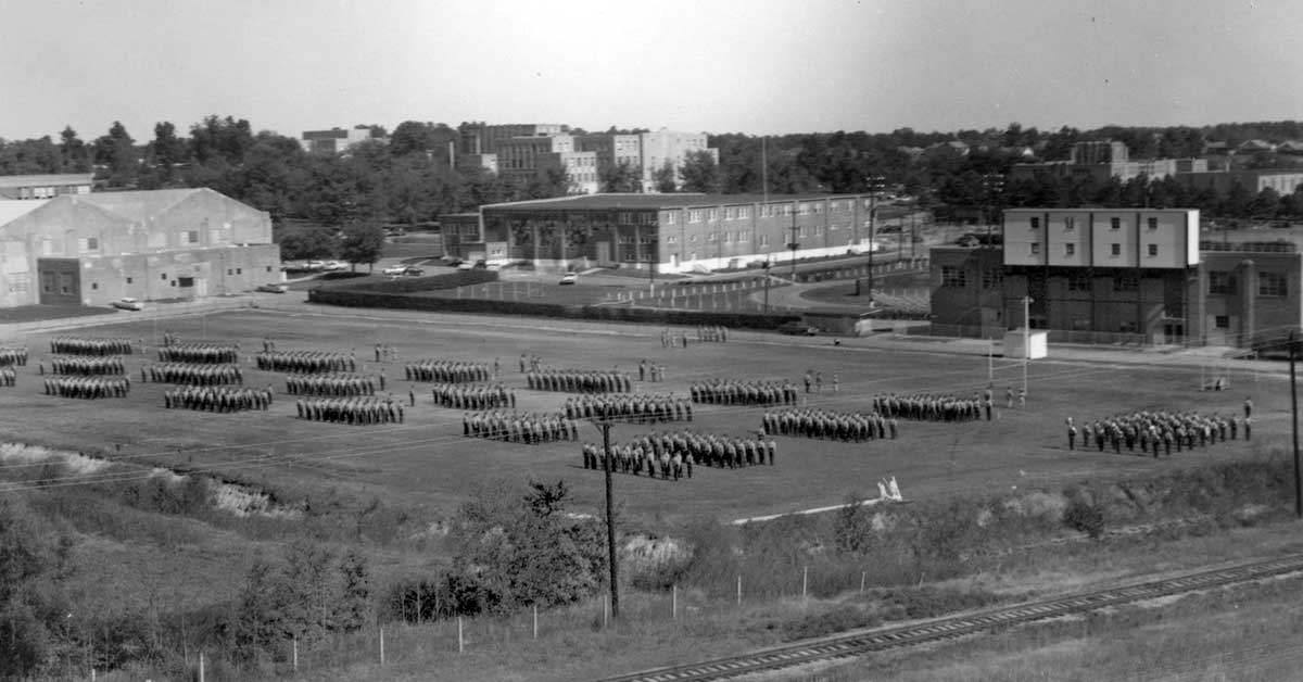 ROTC annual formal inspection (AFI), about 1965, at the drill field where the Health, Physical Education and Sport Sciences Building now stands.  Wilson Hall, Computer Science and Mathematics Building and Arkansas Hall  are among the buildings in the background.