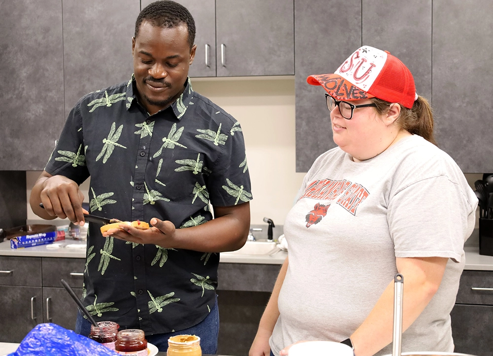 Two H.O.W.L. students learning how to make peanut butter and jelly sandwiches.