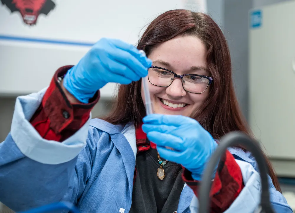 Clinical Lab student holding up a sample and analyzing it.