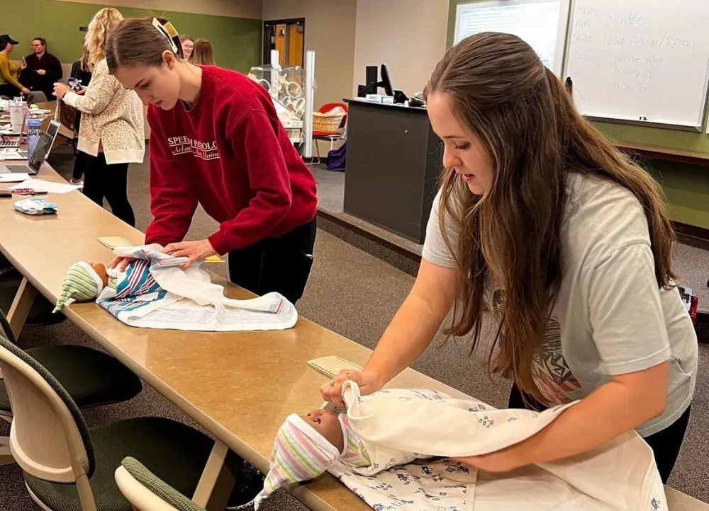 Communication Disorders students working on baby mannequins