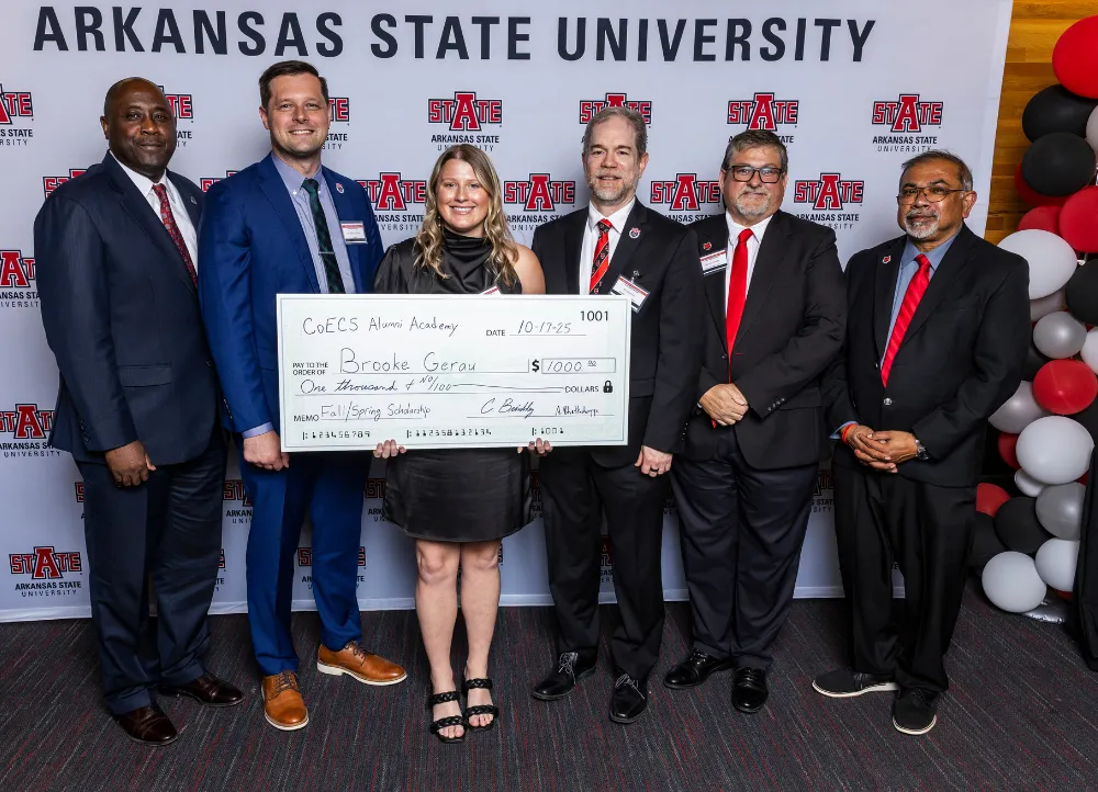 Engineering and Computer Science awarding a large check of one thousand dollars to a memeber of the alumni academy.