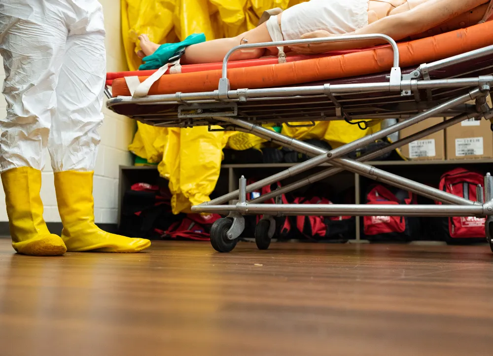 Students in class with hazmat suits and a stretcher.