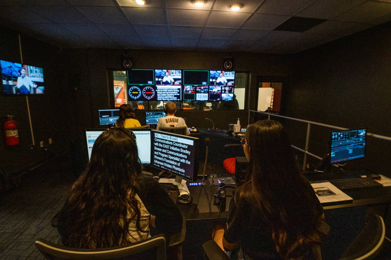 Students in a control room watching a broadcast.
