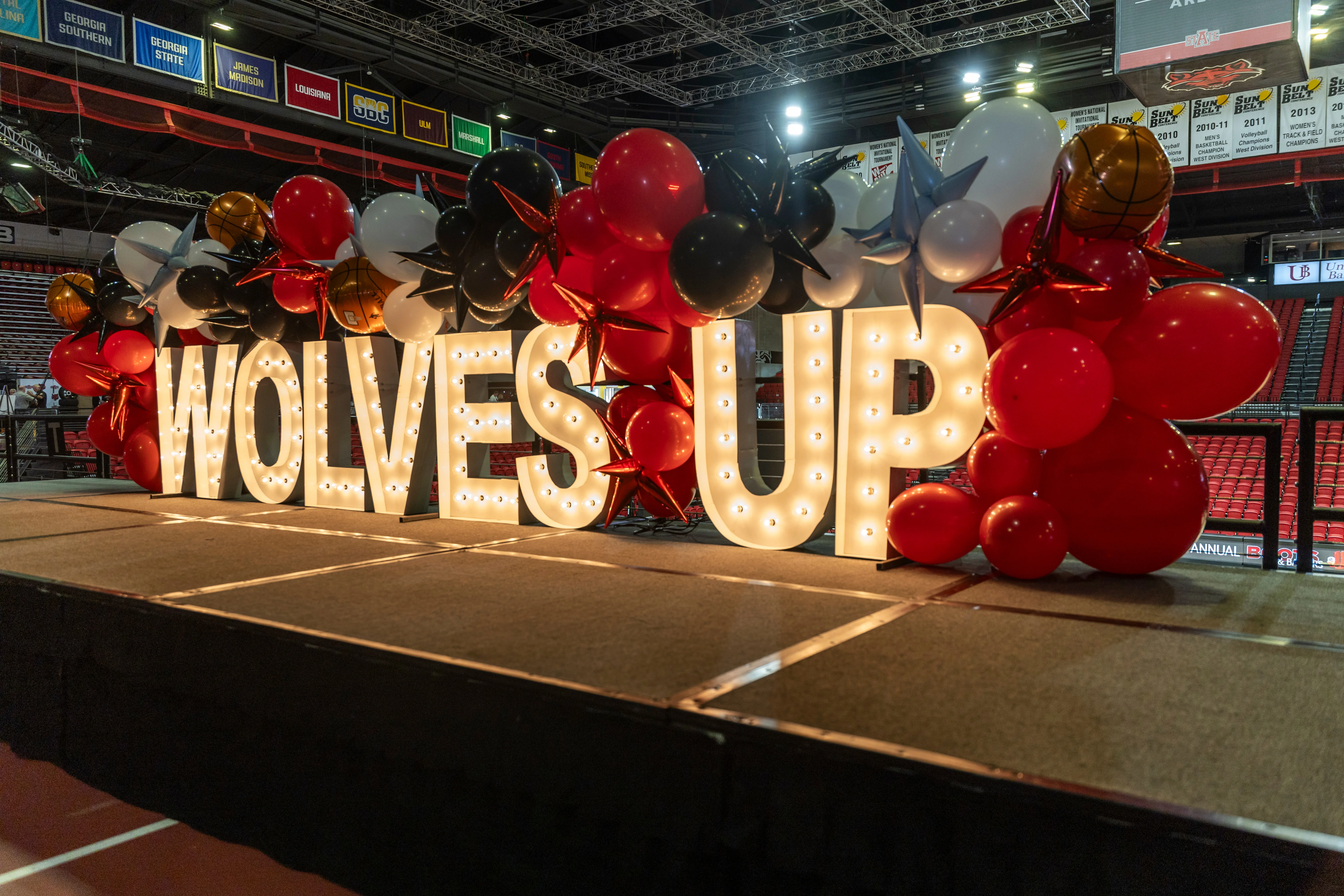 Wolves up event stage with bright lights on a wolves up sign.