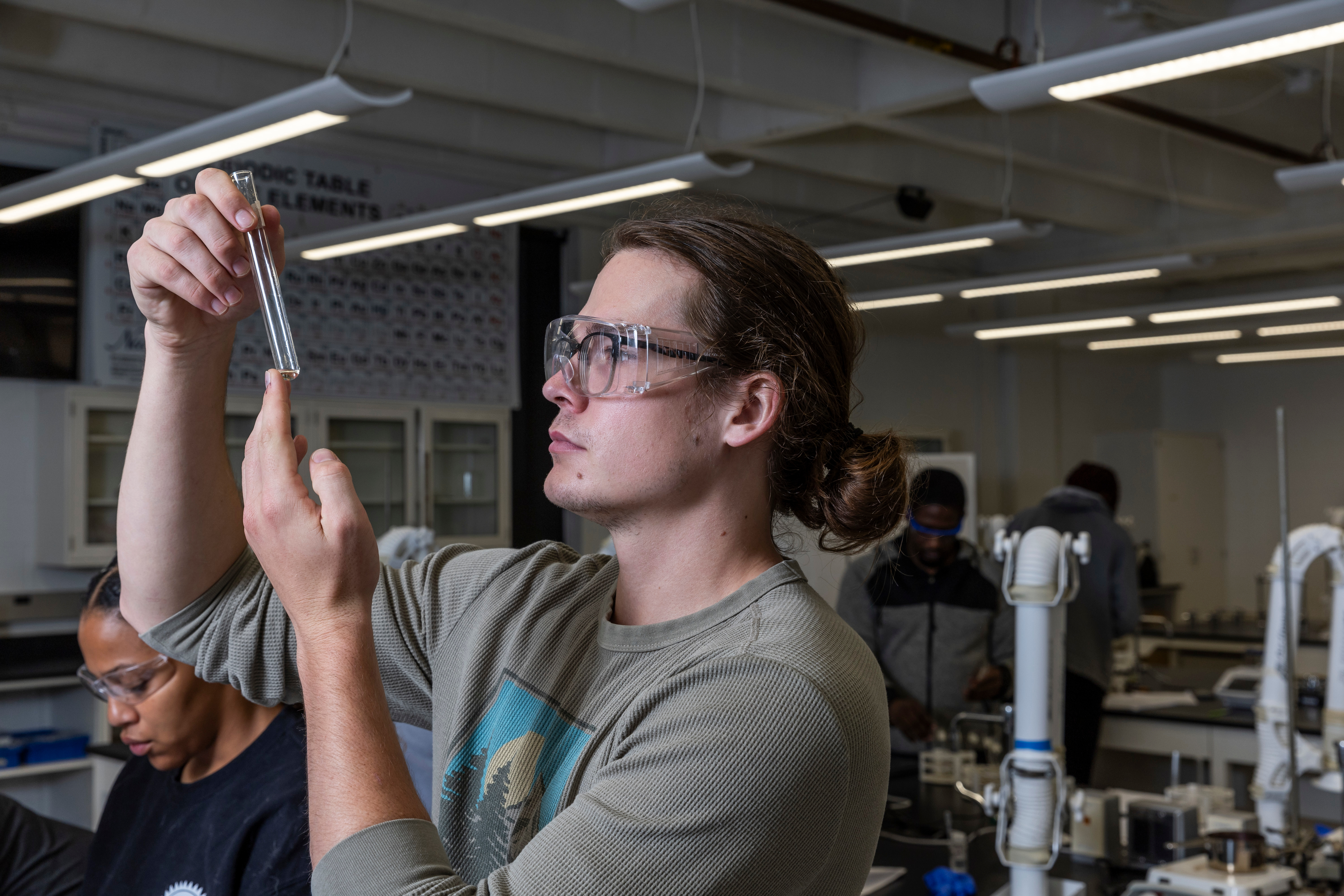 A student examining a test tube.