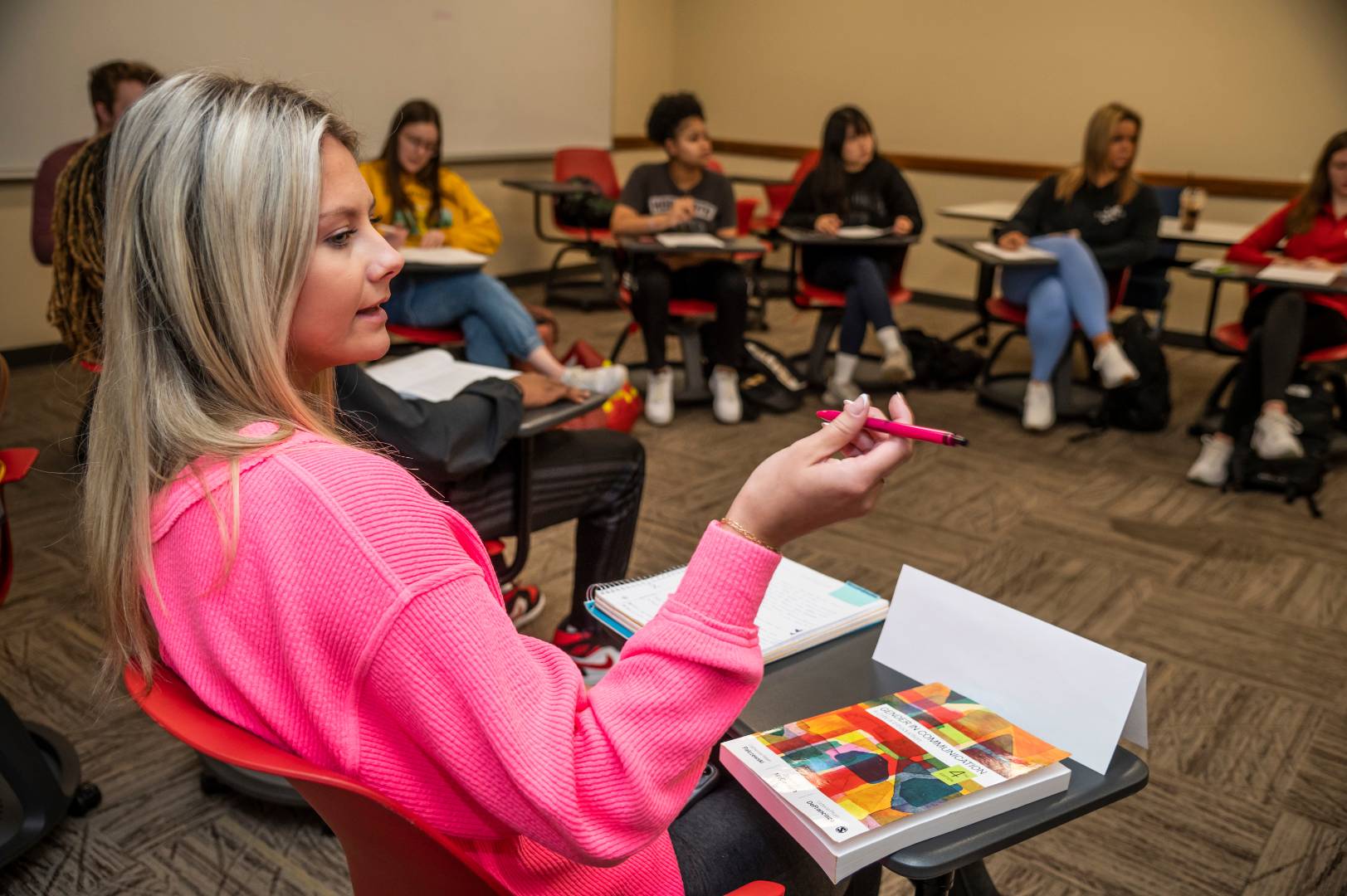 A group of students sitting in a circle and having a class discussion.