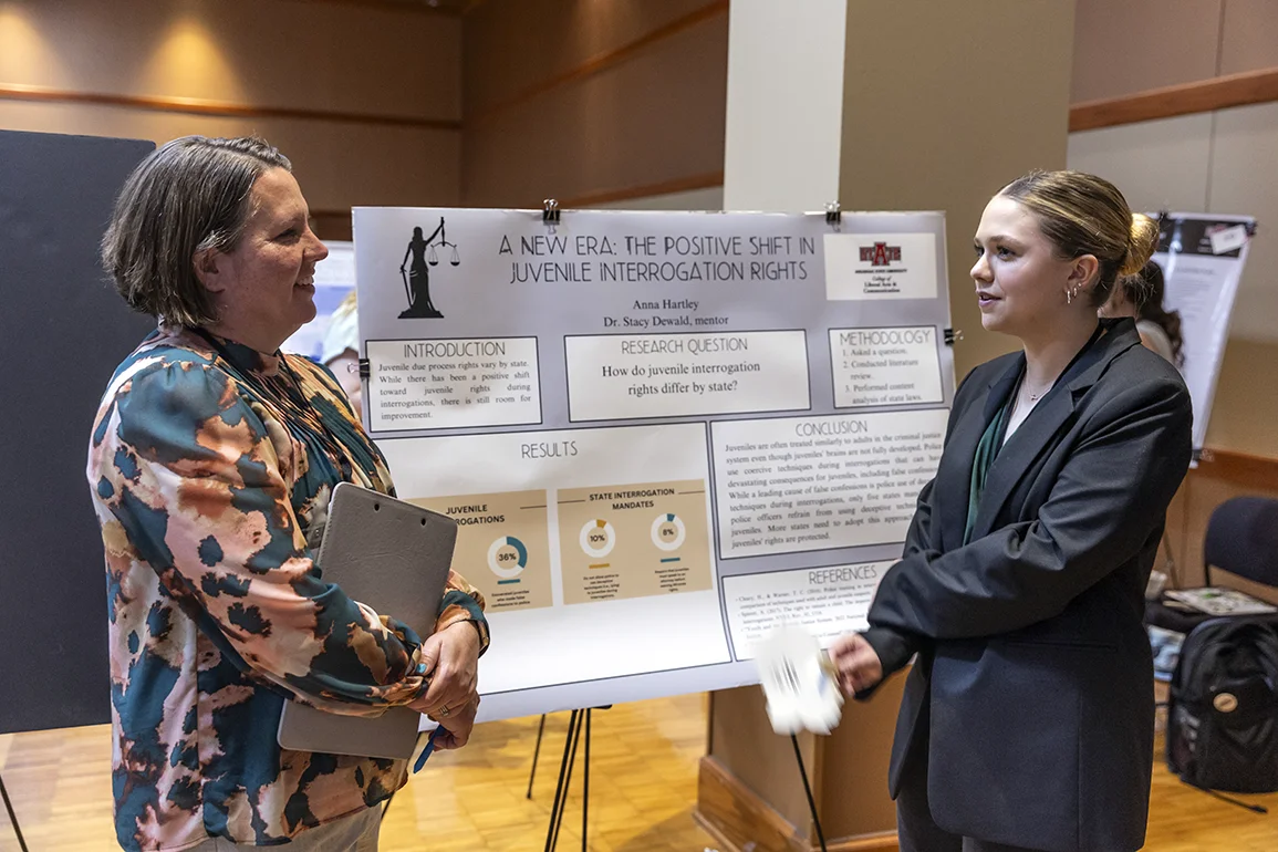 A student and professor discussing a presentation about youth and the justice system.