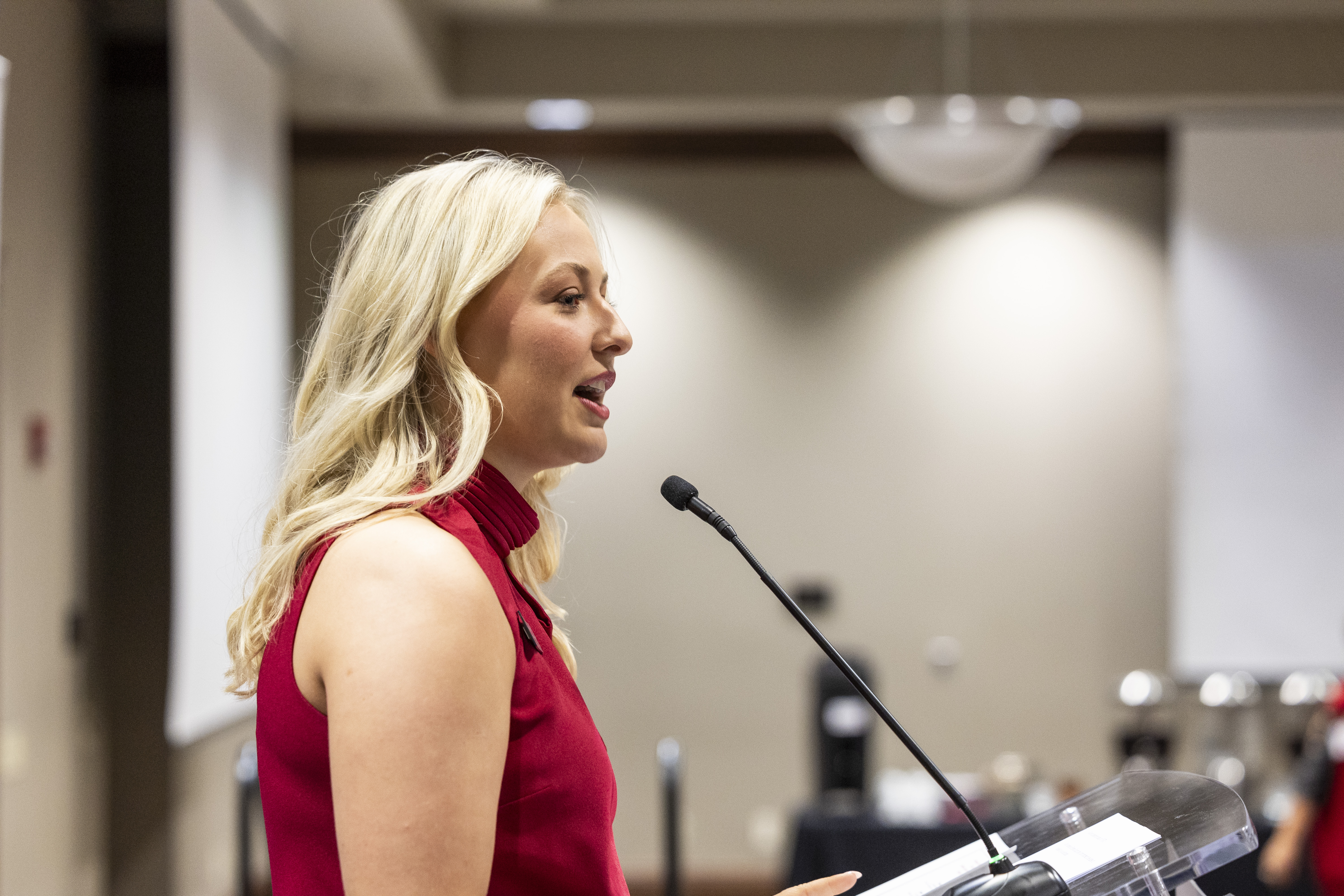 A woman giving a speech at a podium.