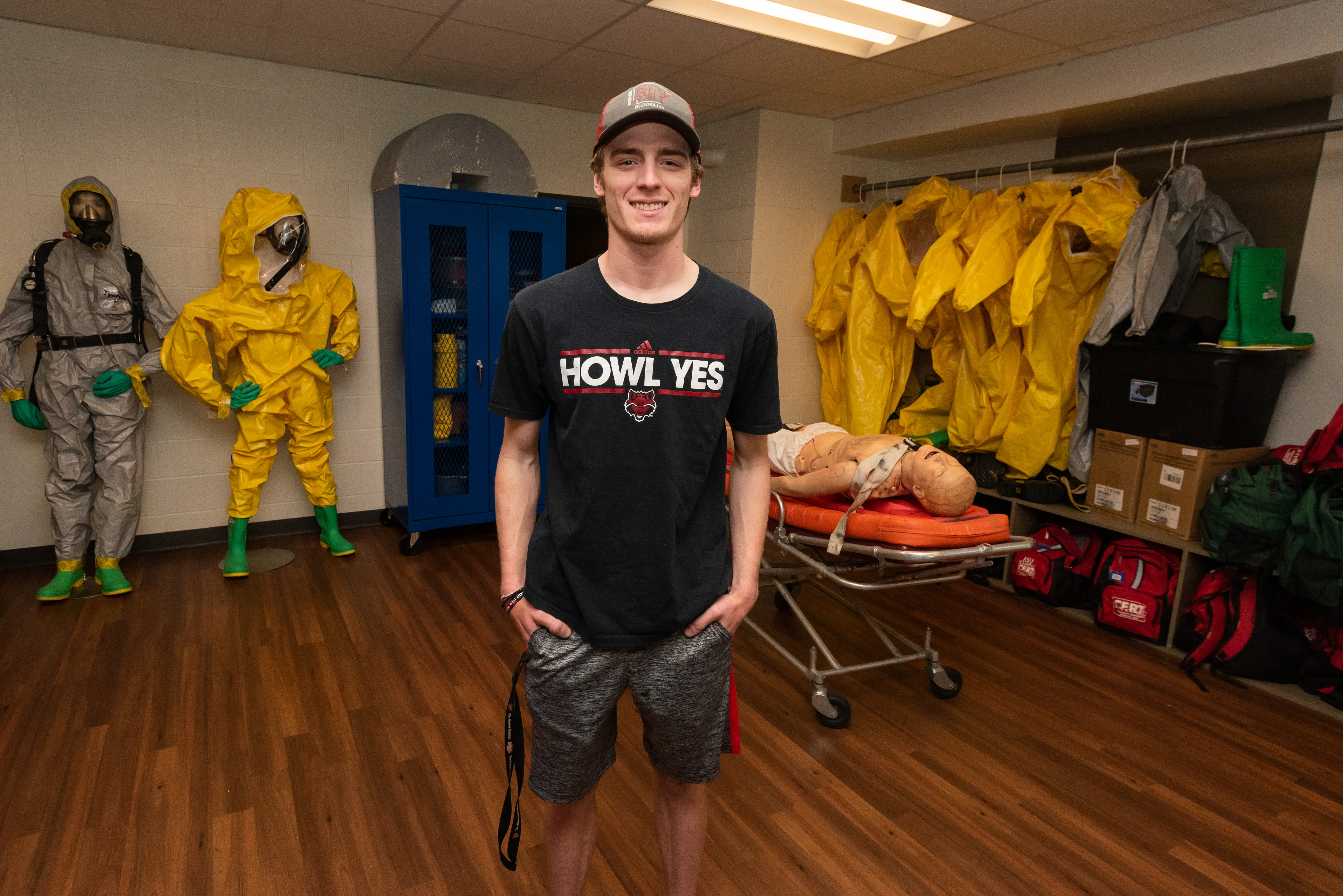 Disaster Training student in a room with stretcher and hazmat suits.