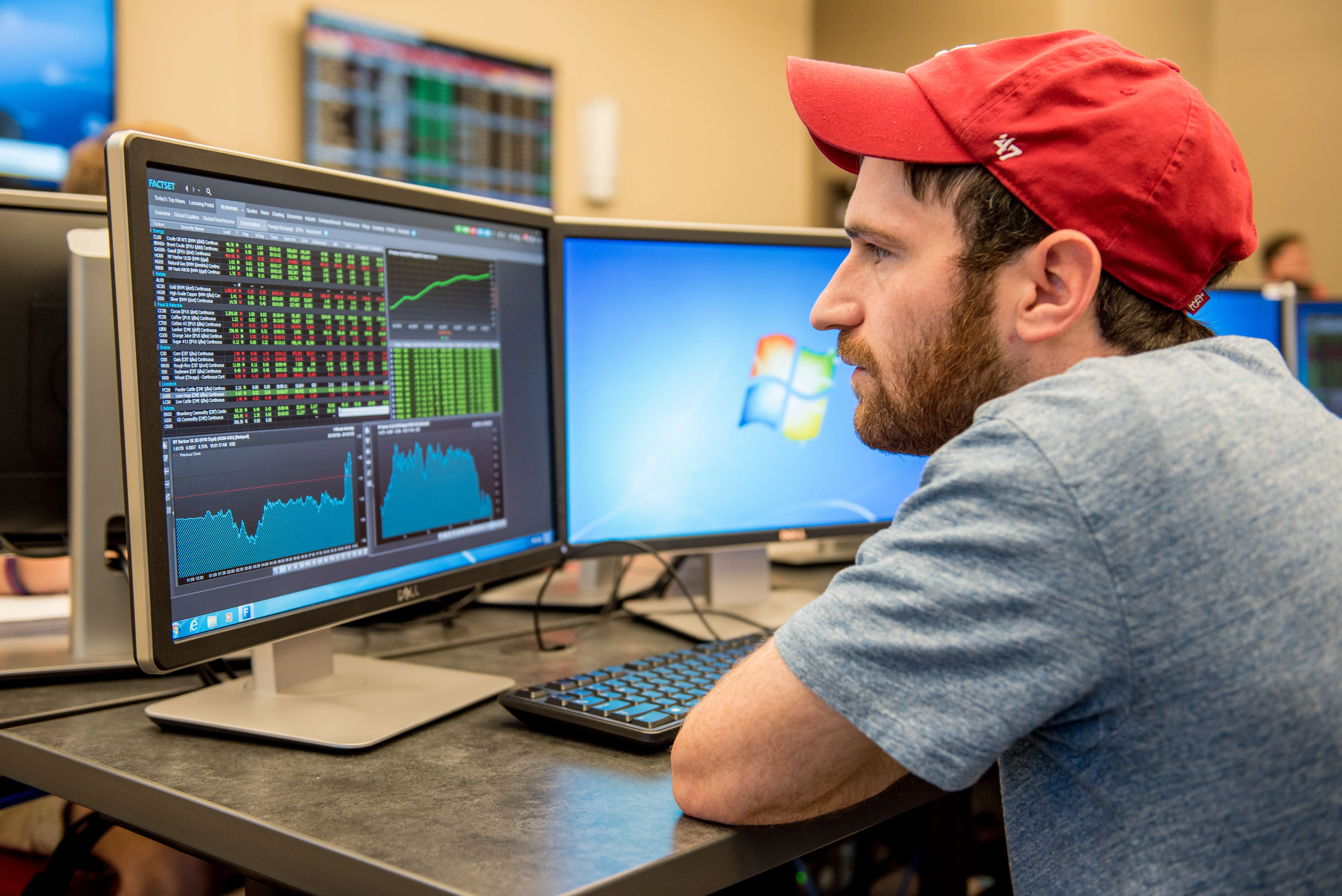 Economics student evaluating stock market fluctuations on computer in classroom. 