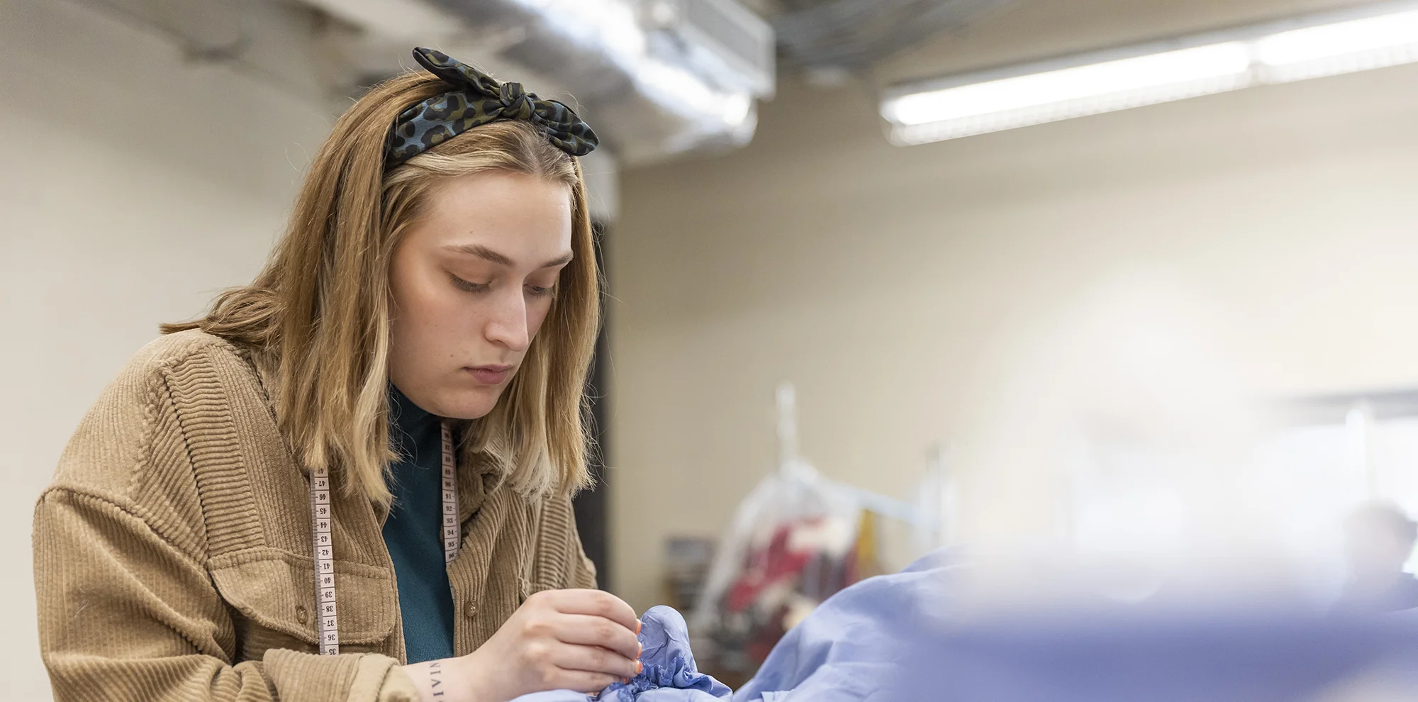Student sewing a garment by hand.