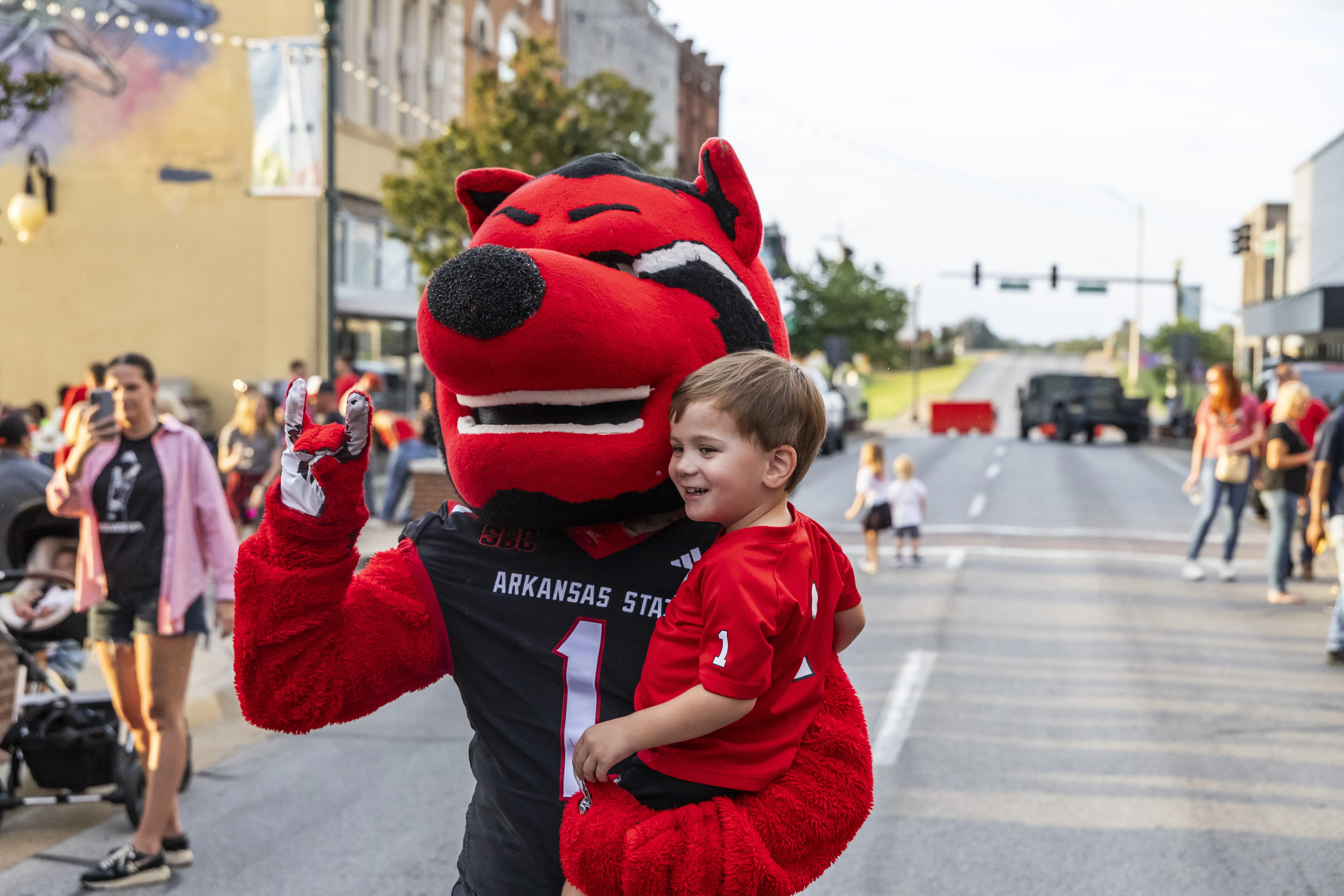 A-State's mascot Howl posing with a child.