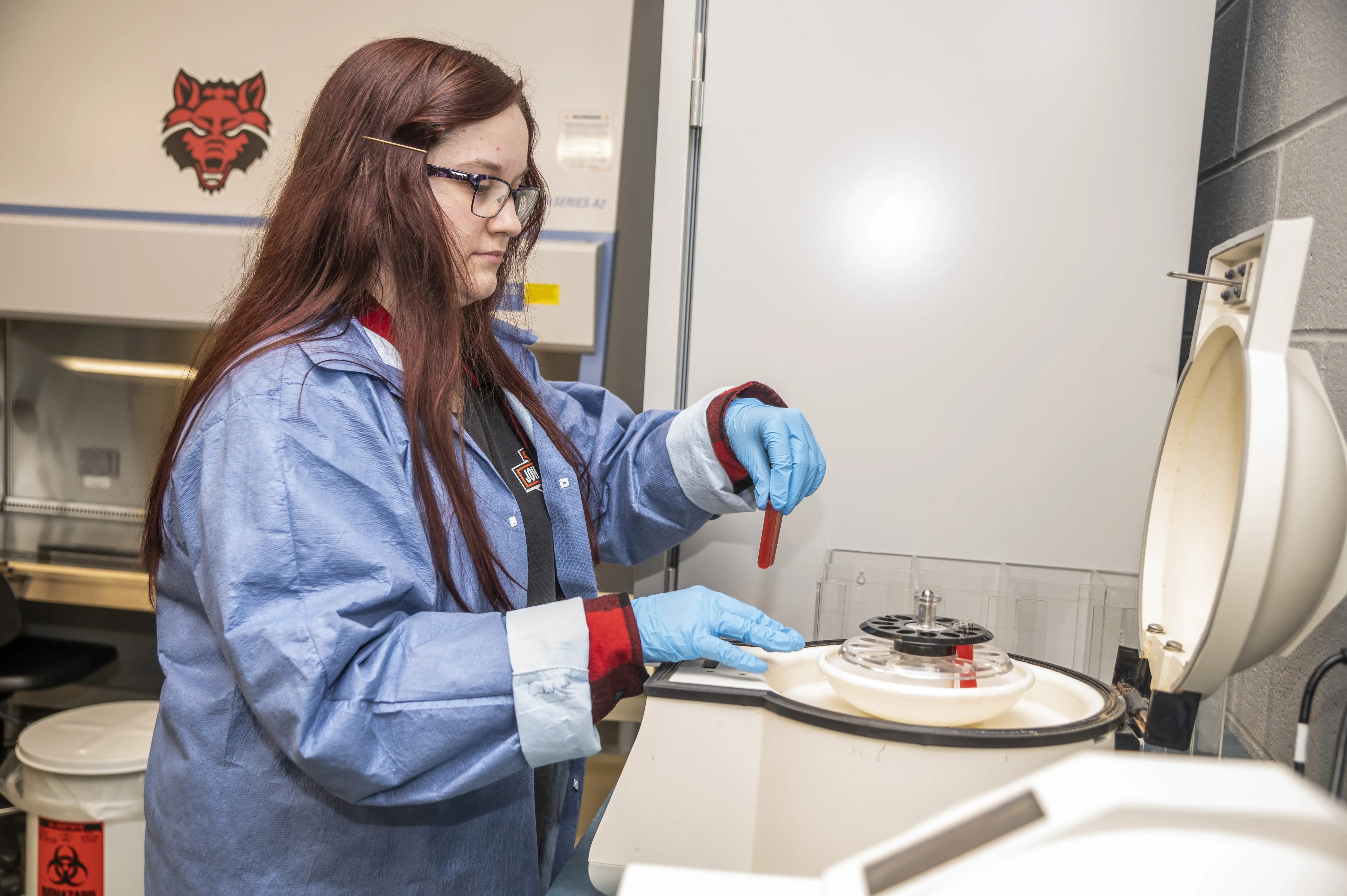 A student in Red Wolf gear using testing blood.