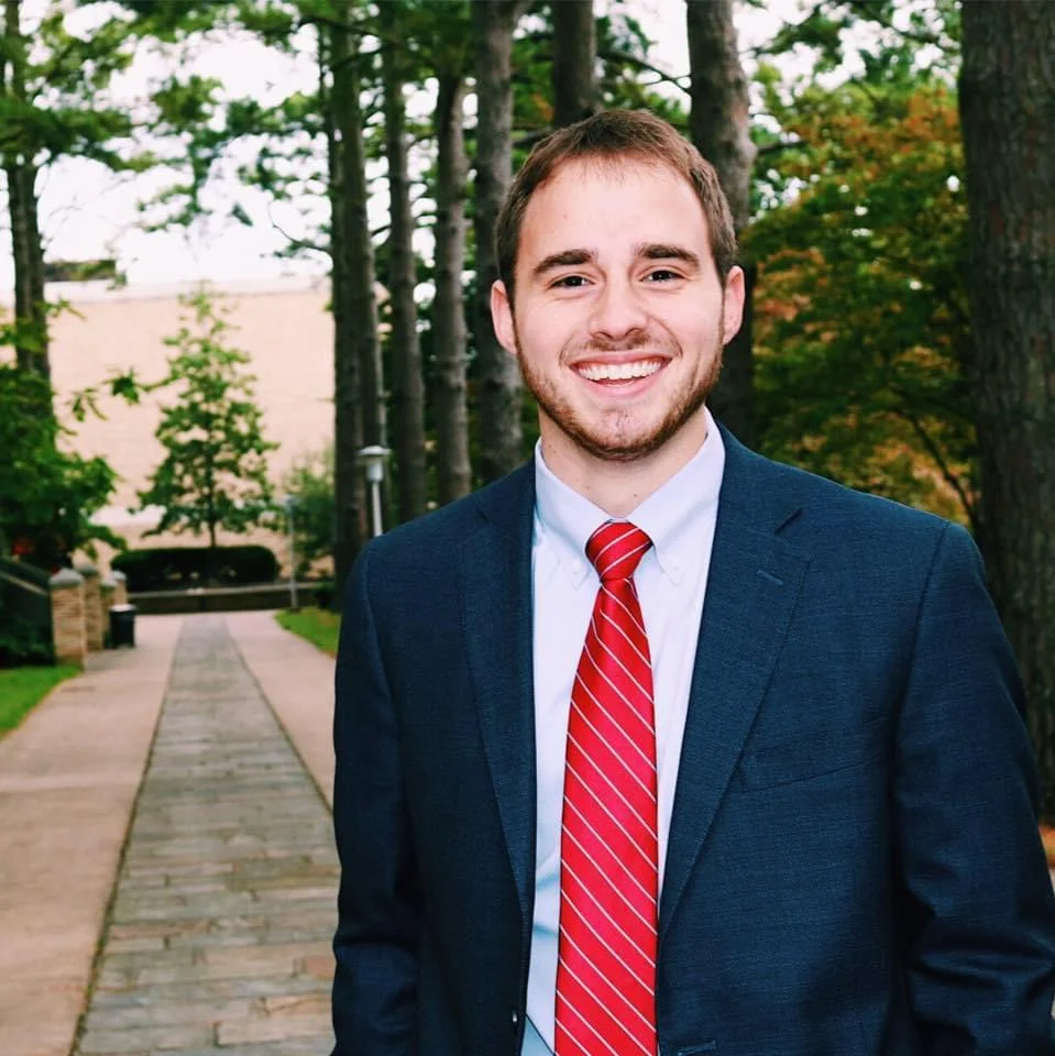 Landen Crancer standing on campus in a suit.
