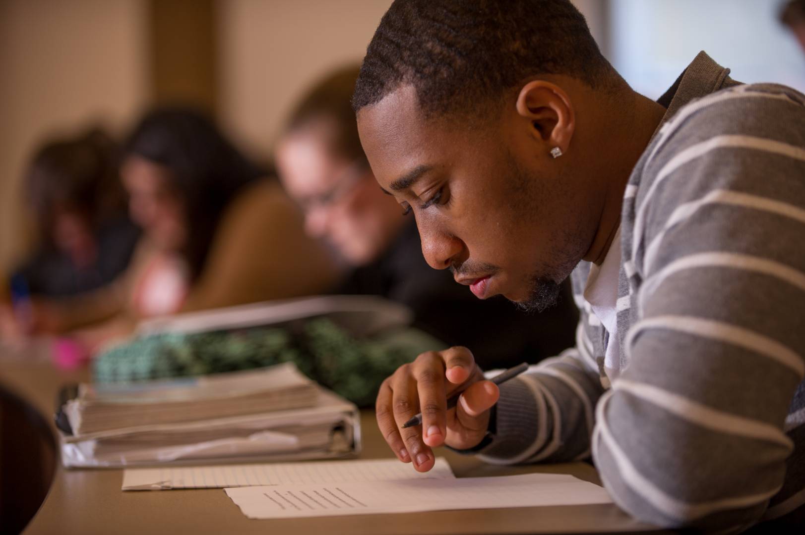 A student looking down at a paper he is writing.