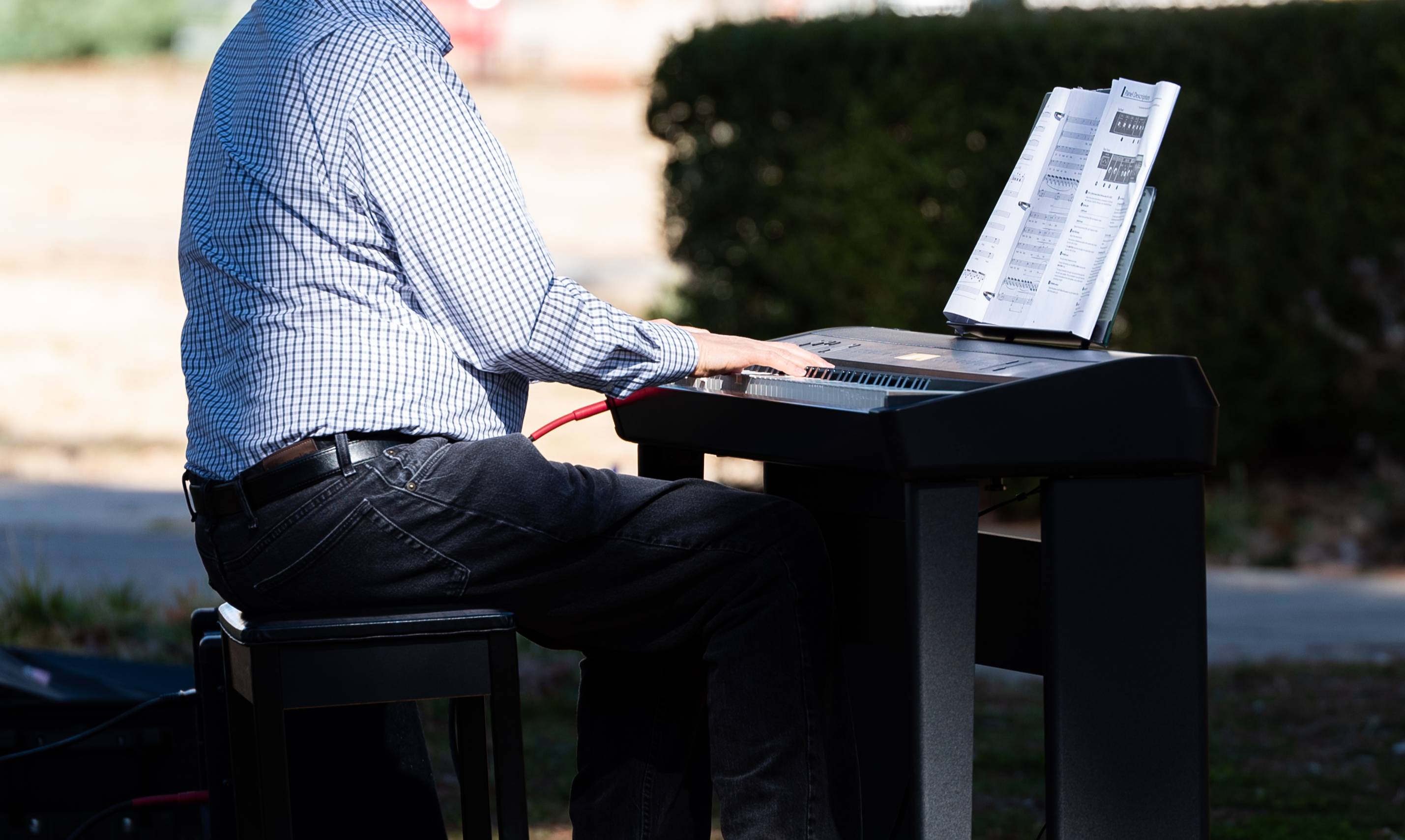 A close-up of someone playing the keyboard outside.
