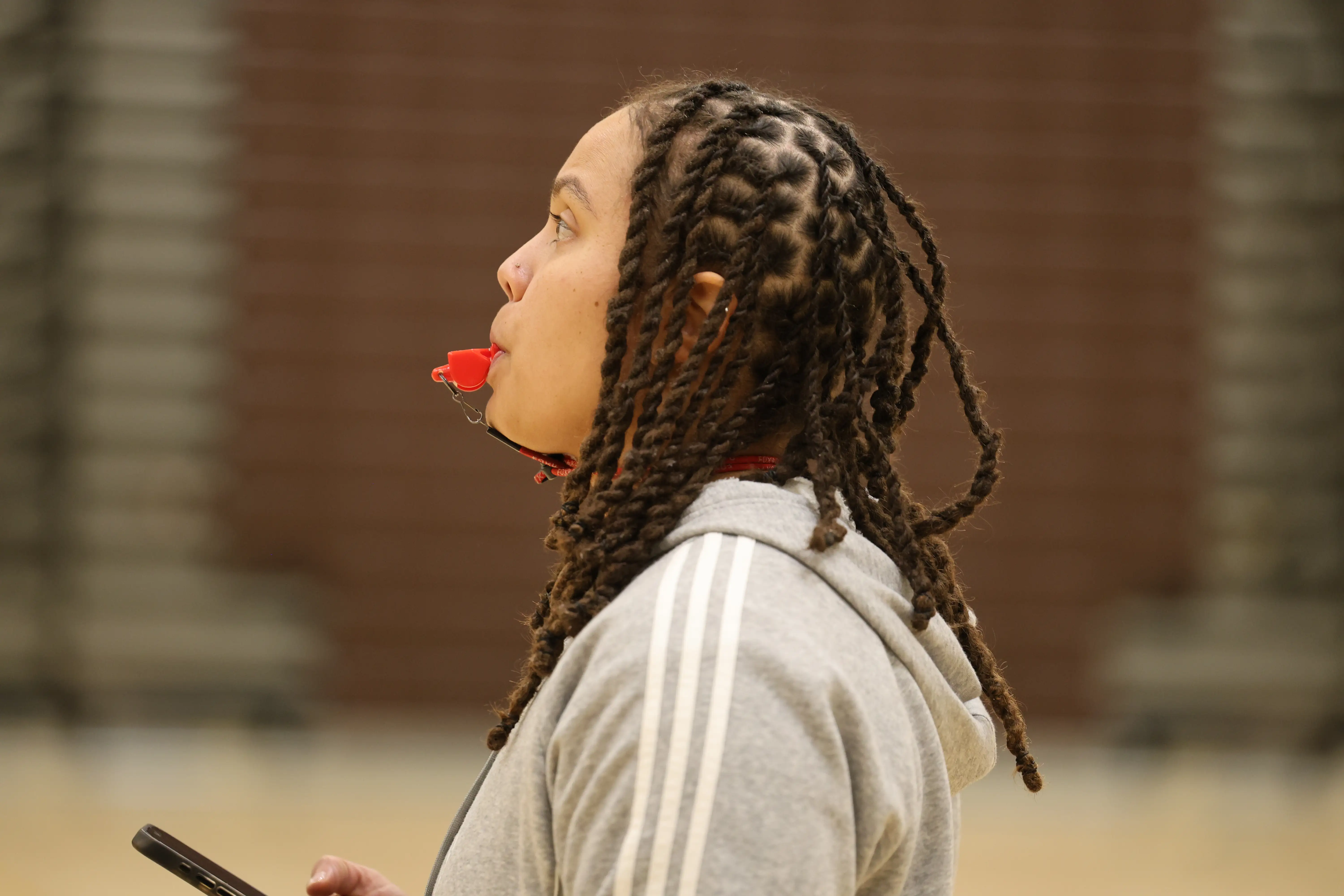 The Women's Basketball coach blowing a whistle.