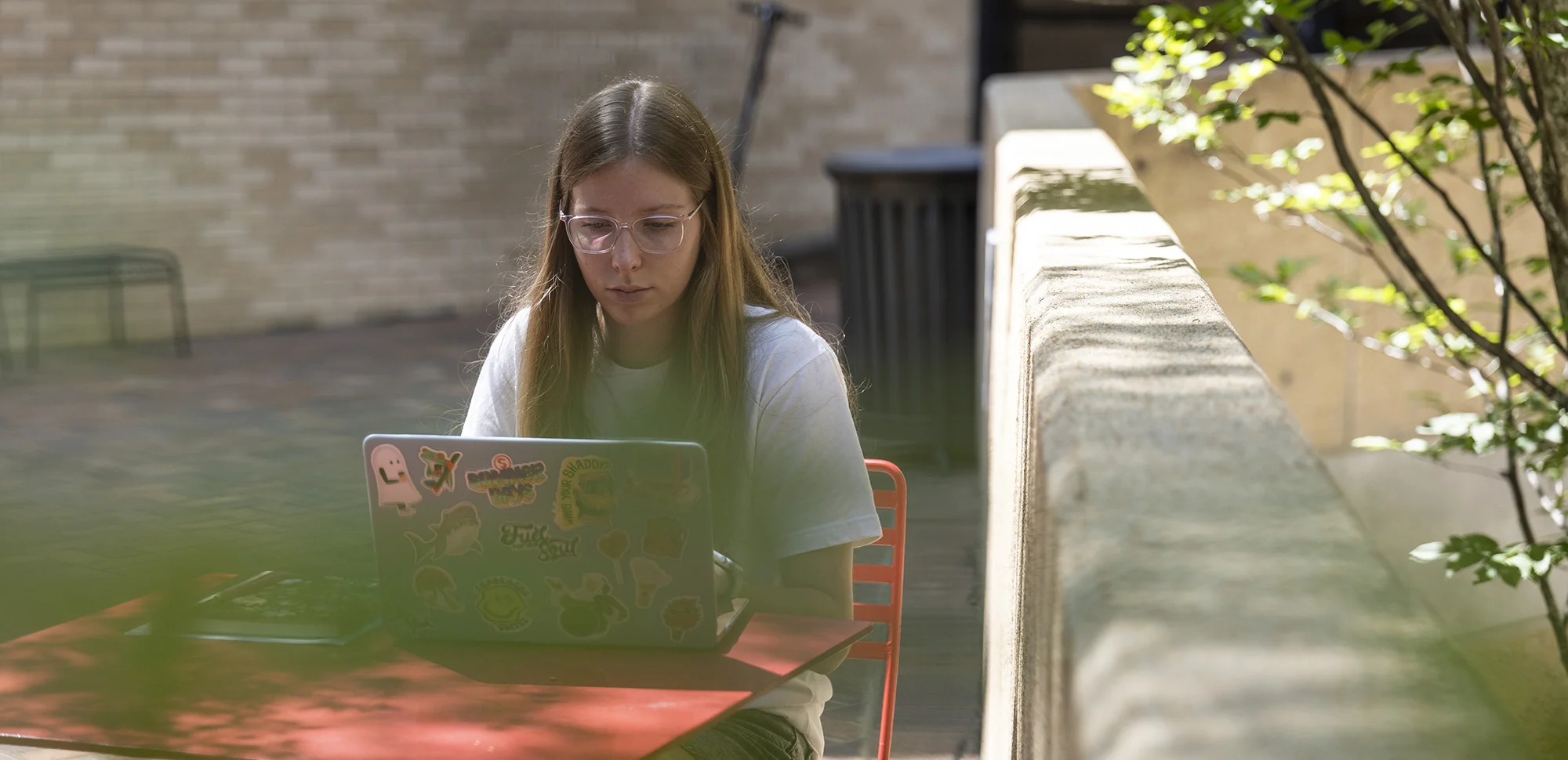 Student using a laptop outdoors on campus.