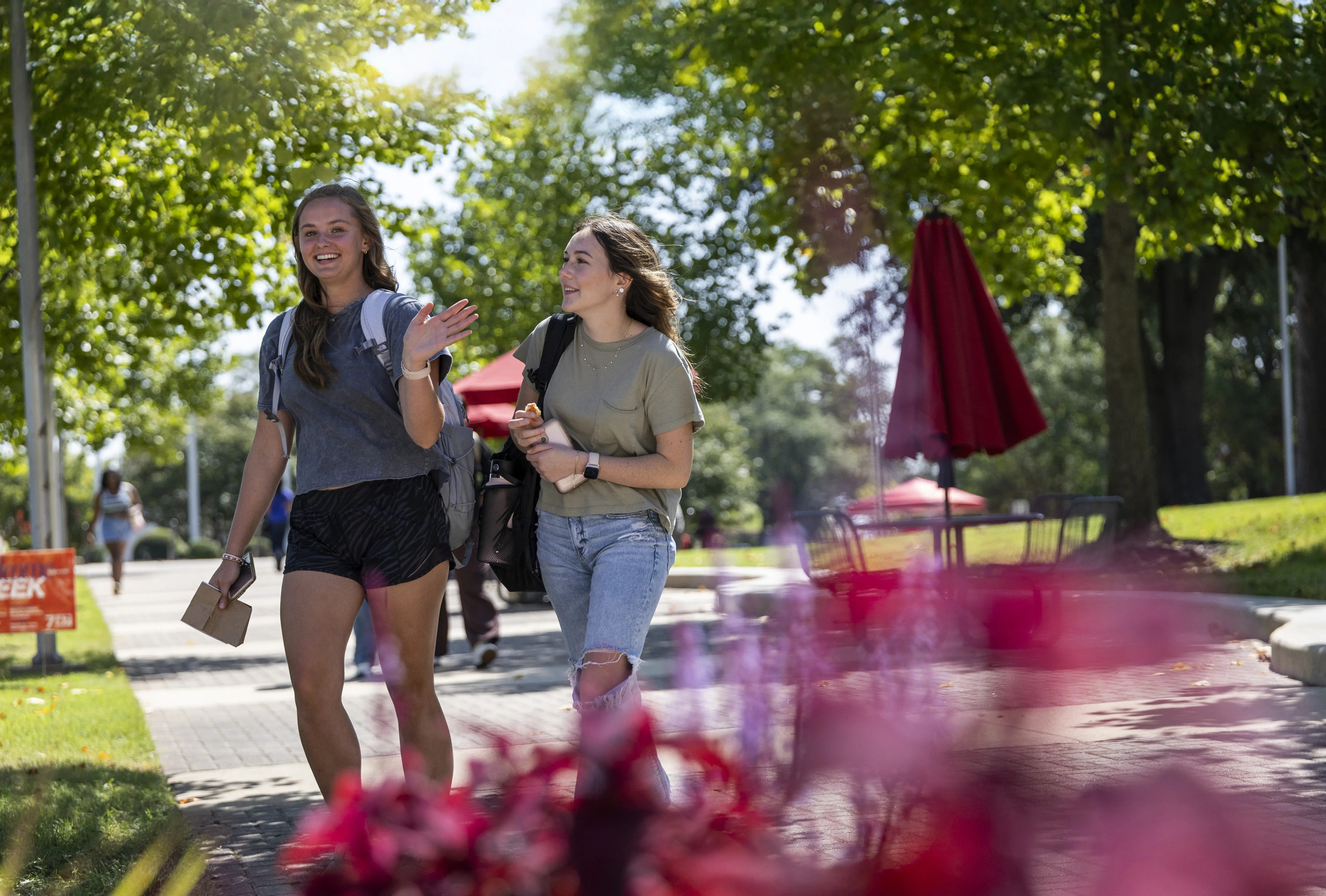 Two students walking on campus and smiling.