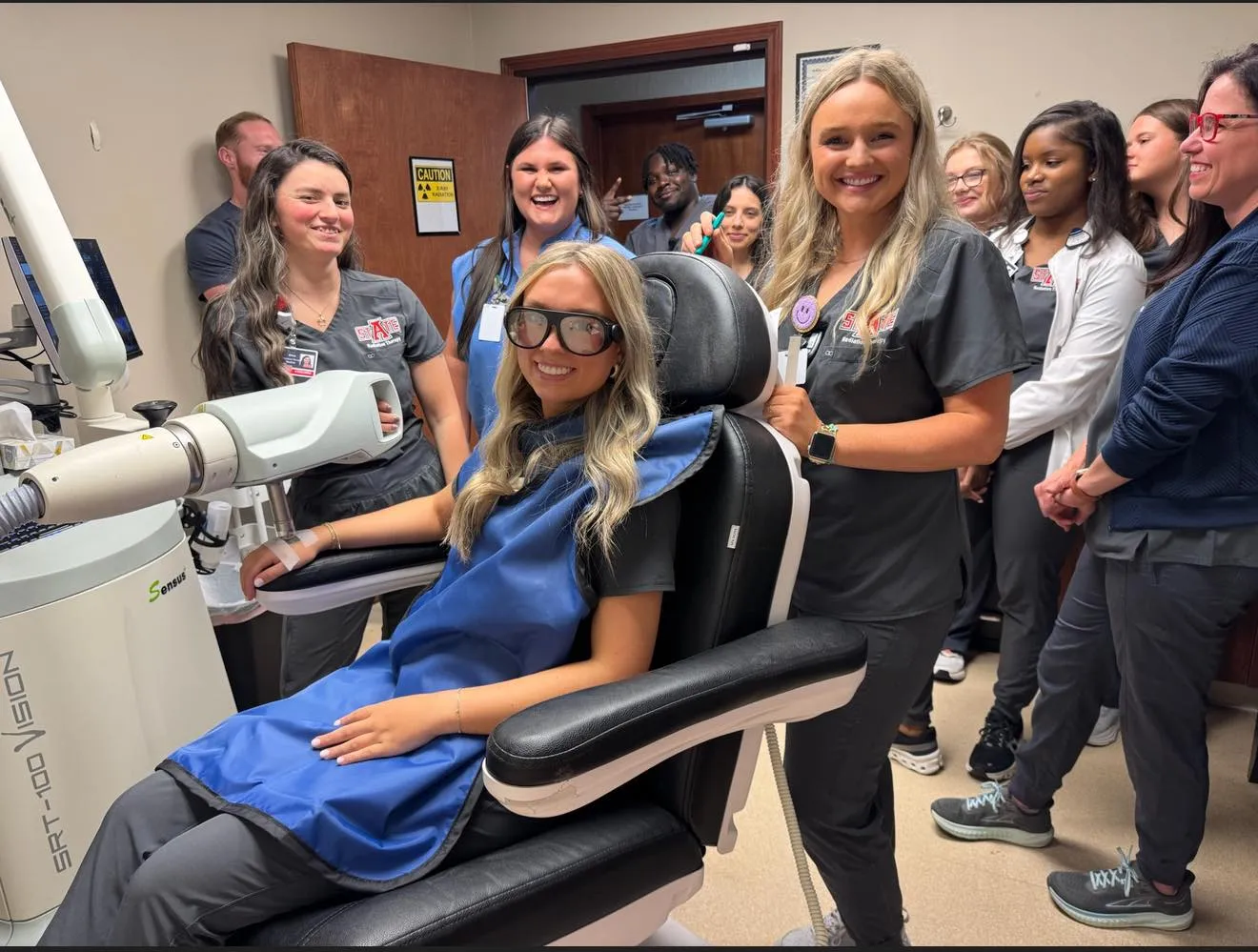 A-State radiation therapy students standing near skin cancer treatment equipment at Sills Dermatology.