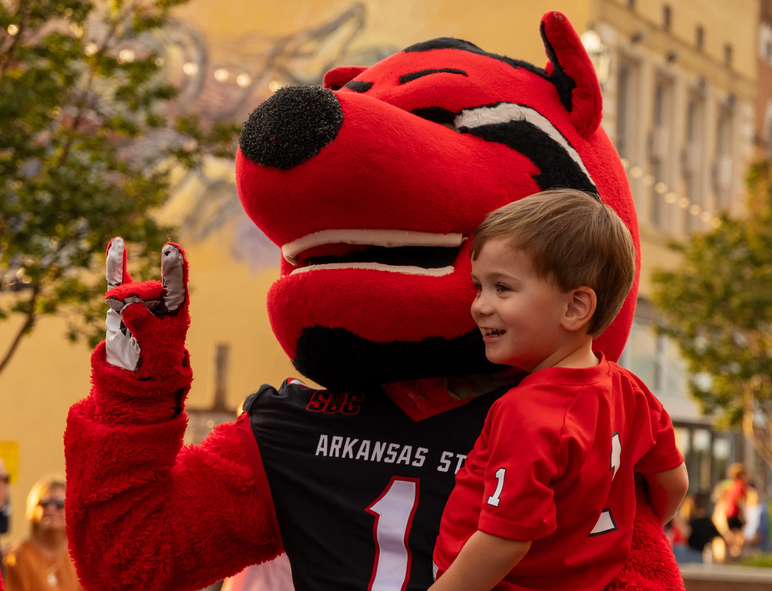 Our mascot, Howl, holding a smiling child.