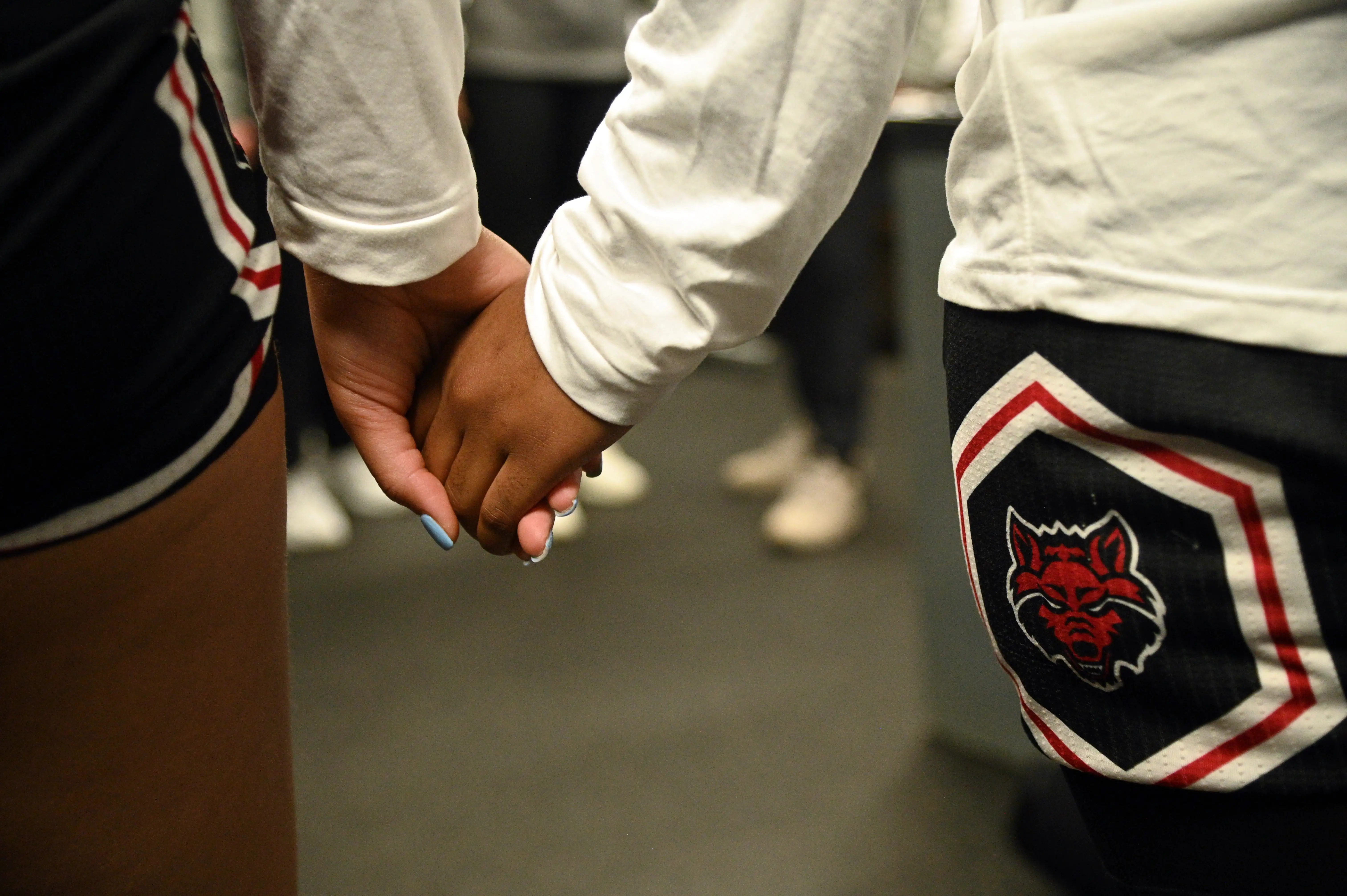 A close-up of two people holding hands.