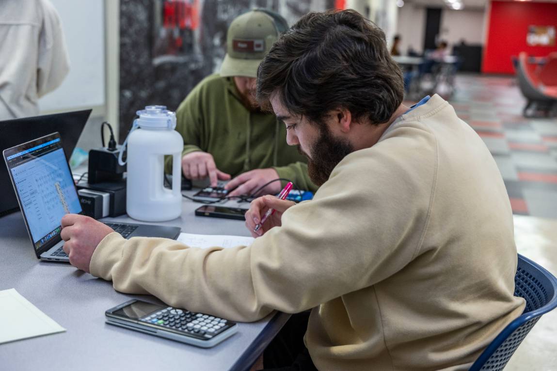 A student working on problems at a laptop.