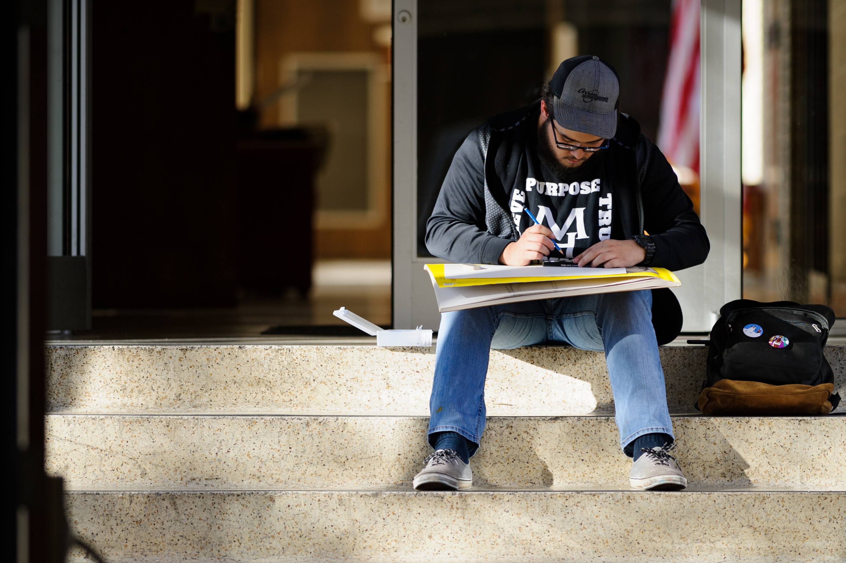 A student drawing on a staircase.