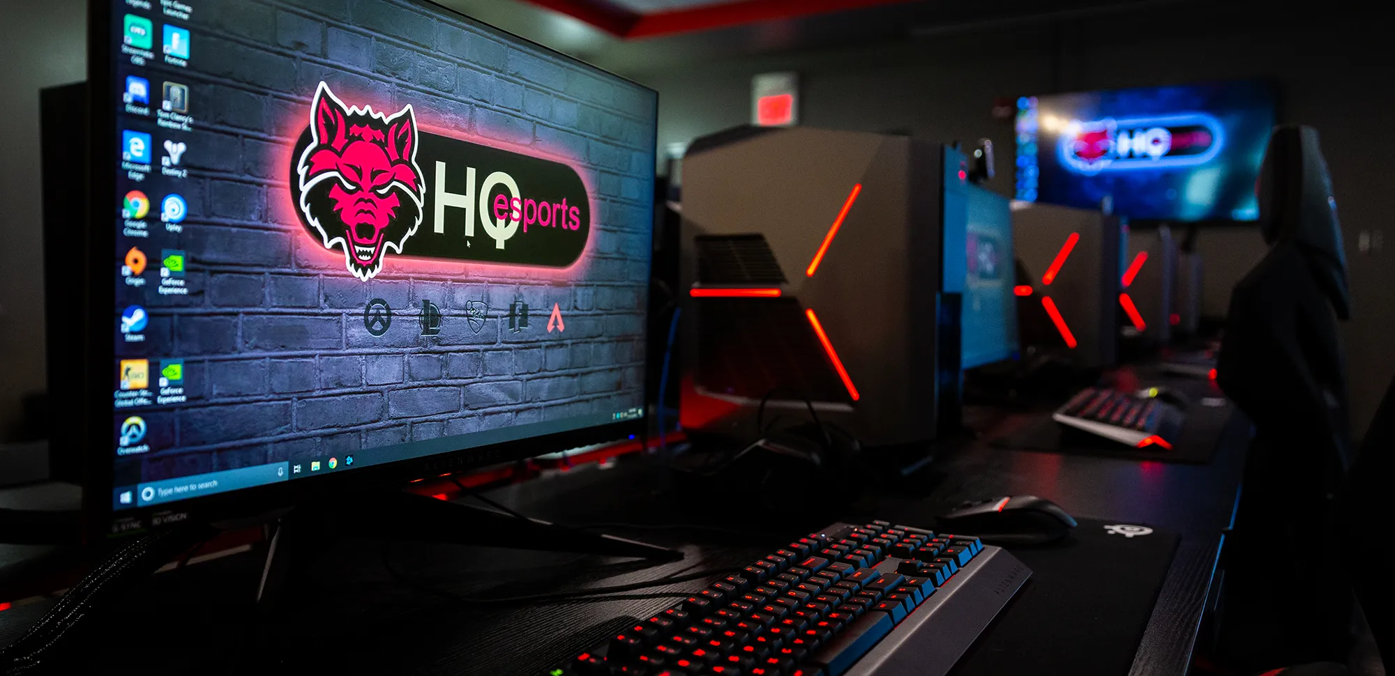 Gaming computers with the Red Wolves logo as their backgrounds.